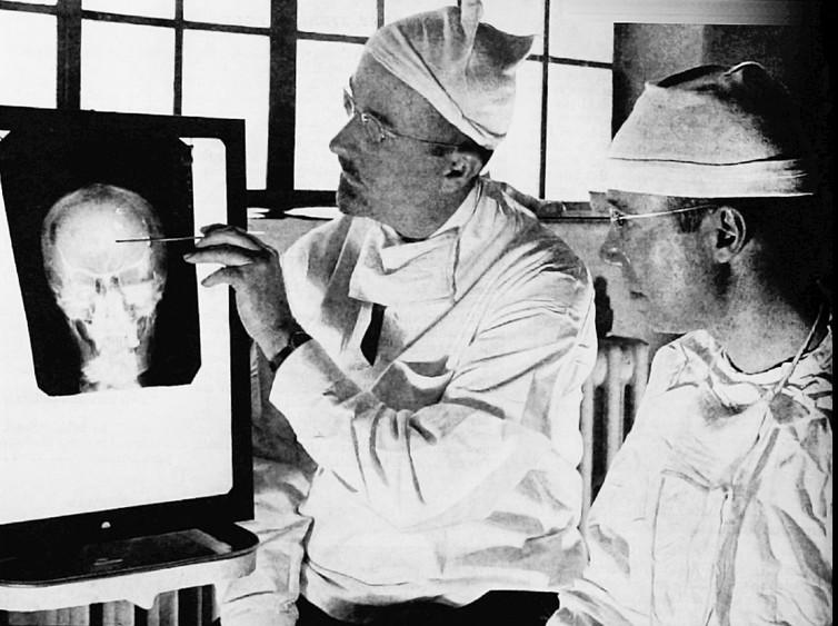 Walter Freeman (left) and James Watts study an x-ray prior to conducting ‘psychosurgery’