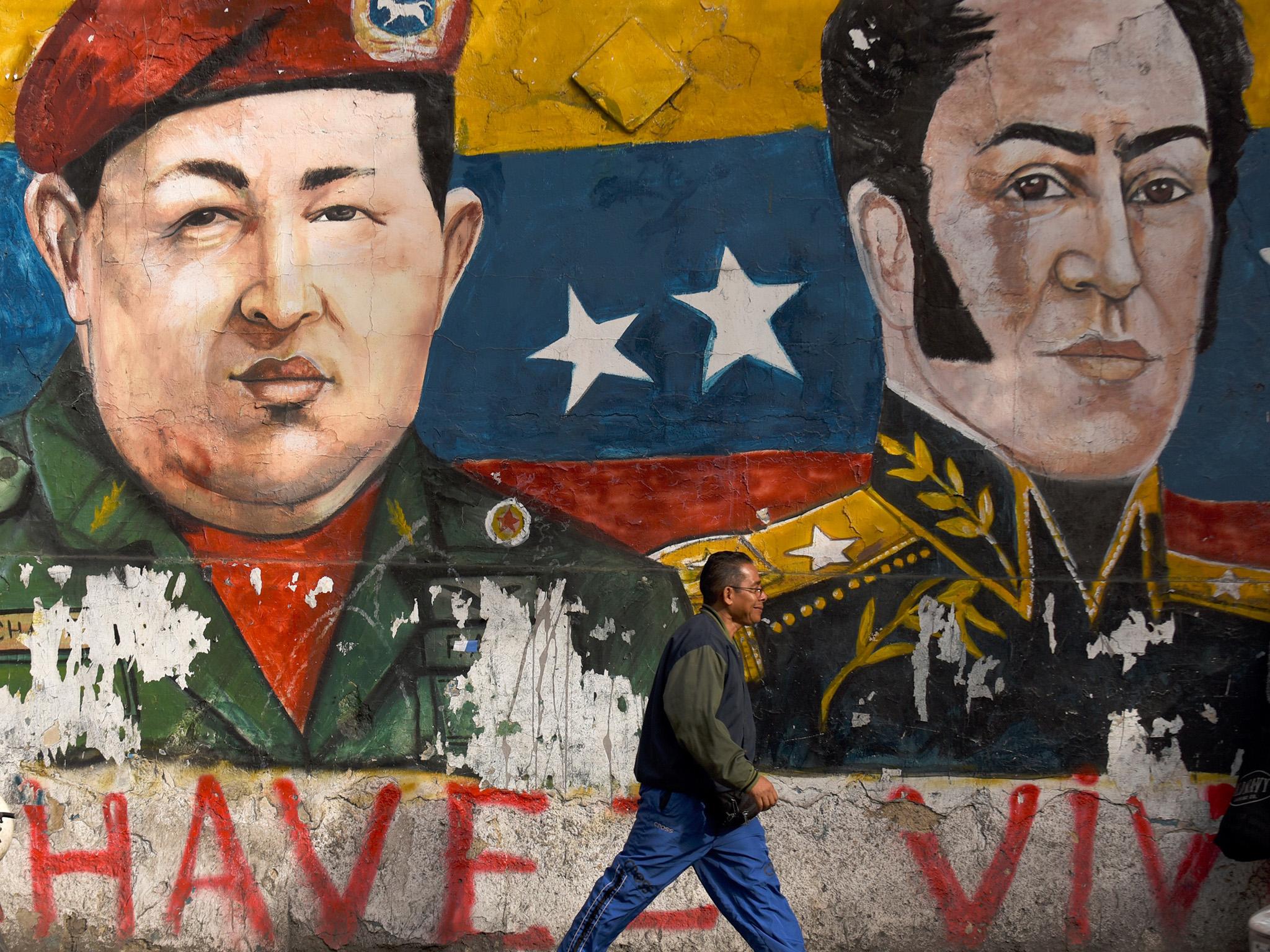 Hugo Chavez, on the left in this Caracas mural, died in 2013. The boom years of his populist presidency now seem a long-distant memory