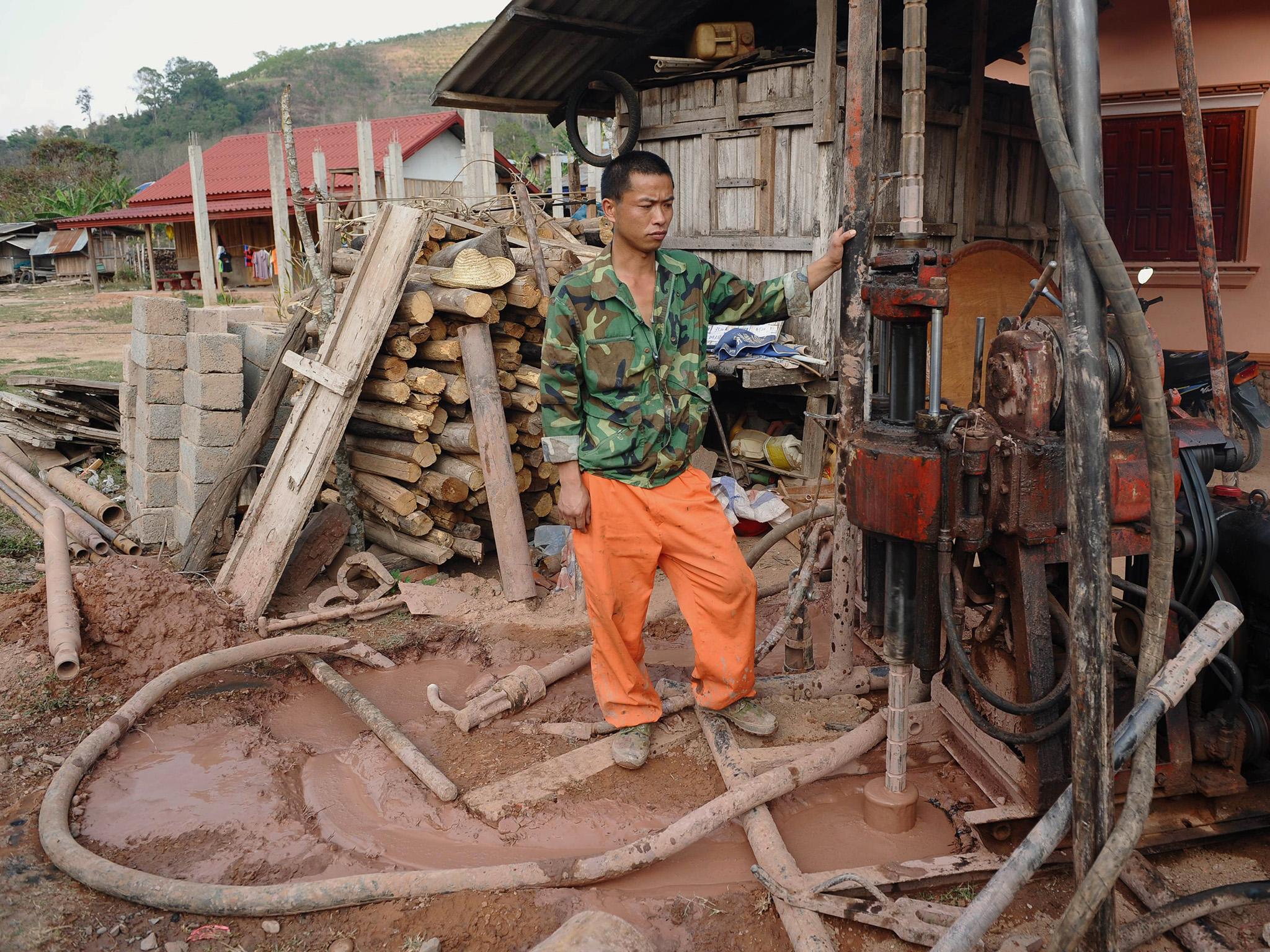 Chinese workers drill for soil analyses at Bopiat village in the Northern province of Louang Namtha