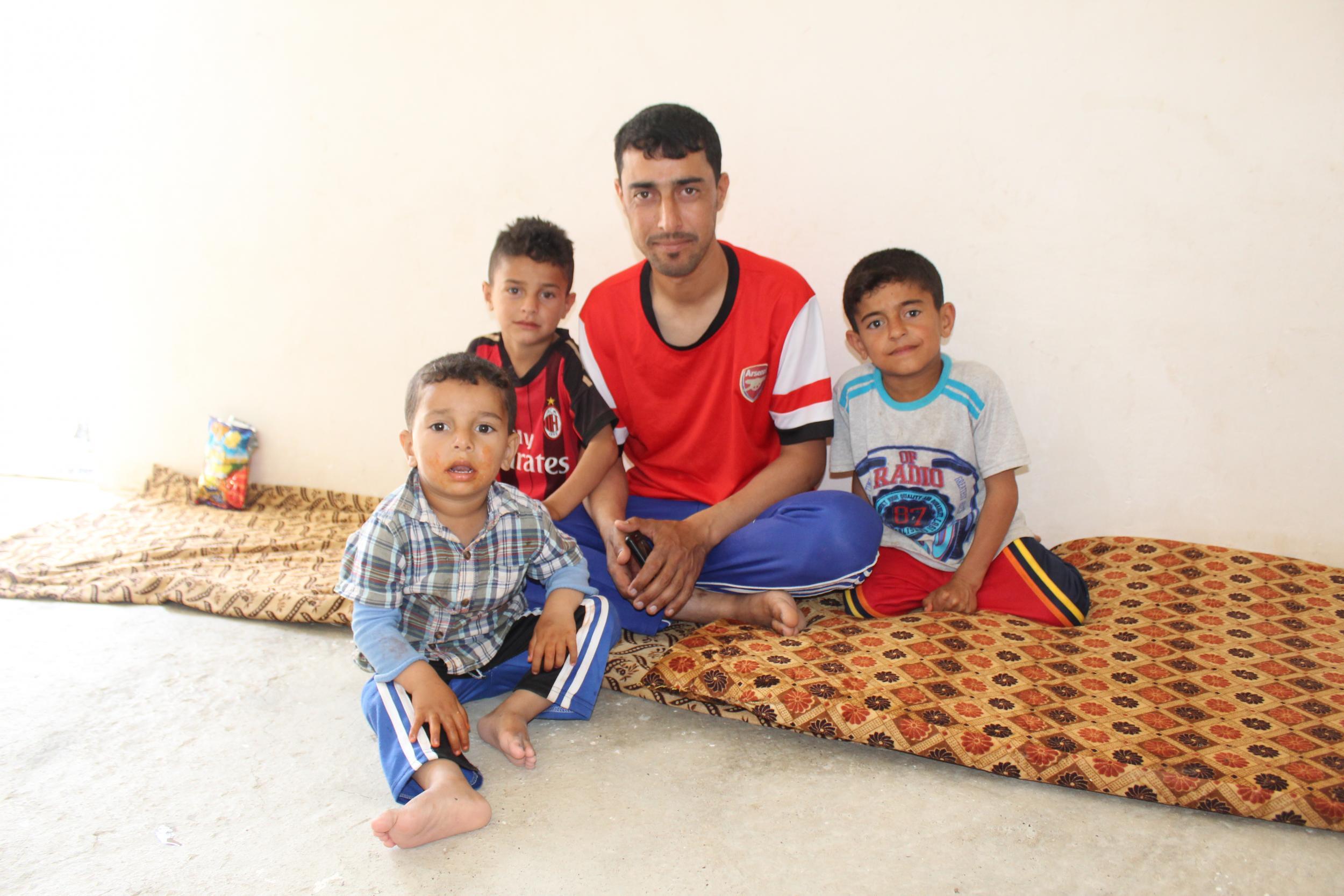 Hassan with his father and brothers in their home in Dibaga 2, south of Mosul. The family do not know how long they will have to stay in the IDP camp