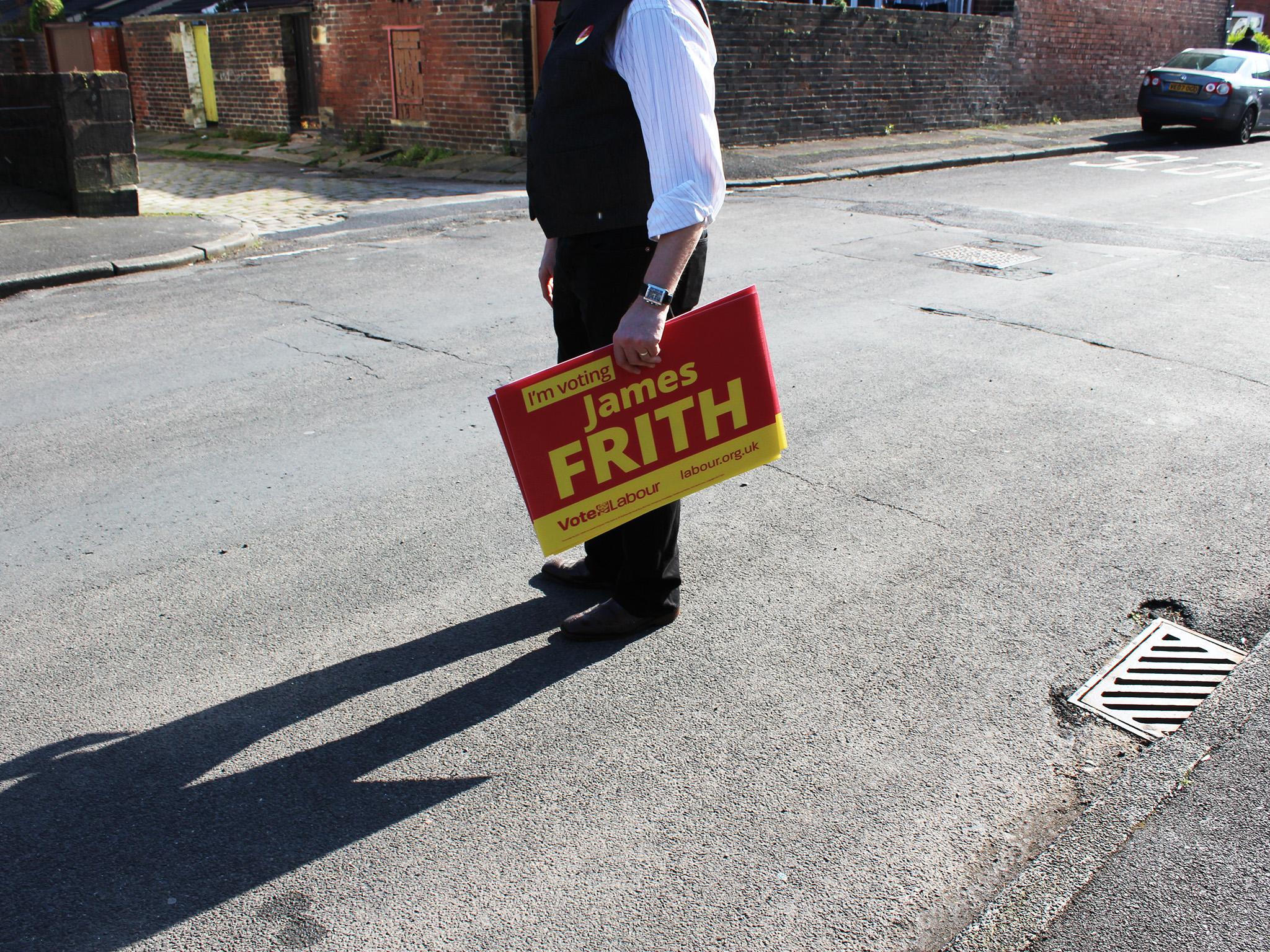 A campaigner holds a placard while door-knocking for Bury North Labour candidate James Frith