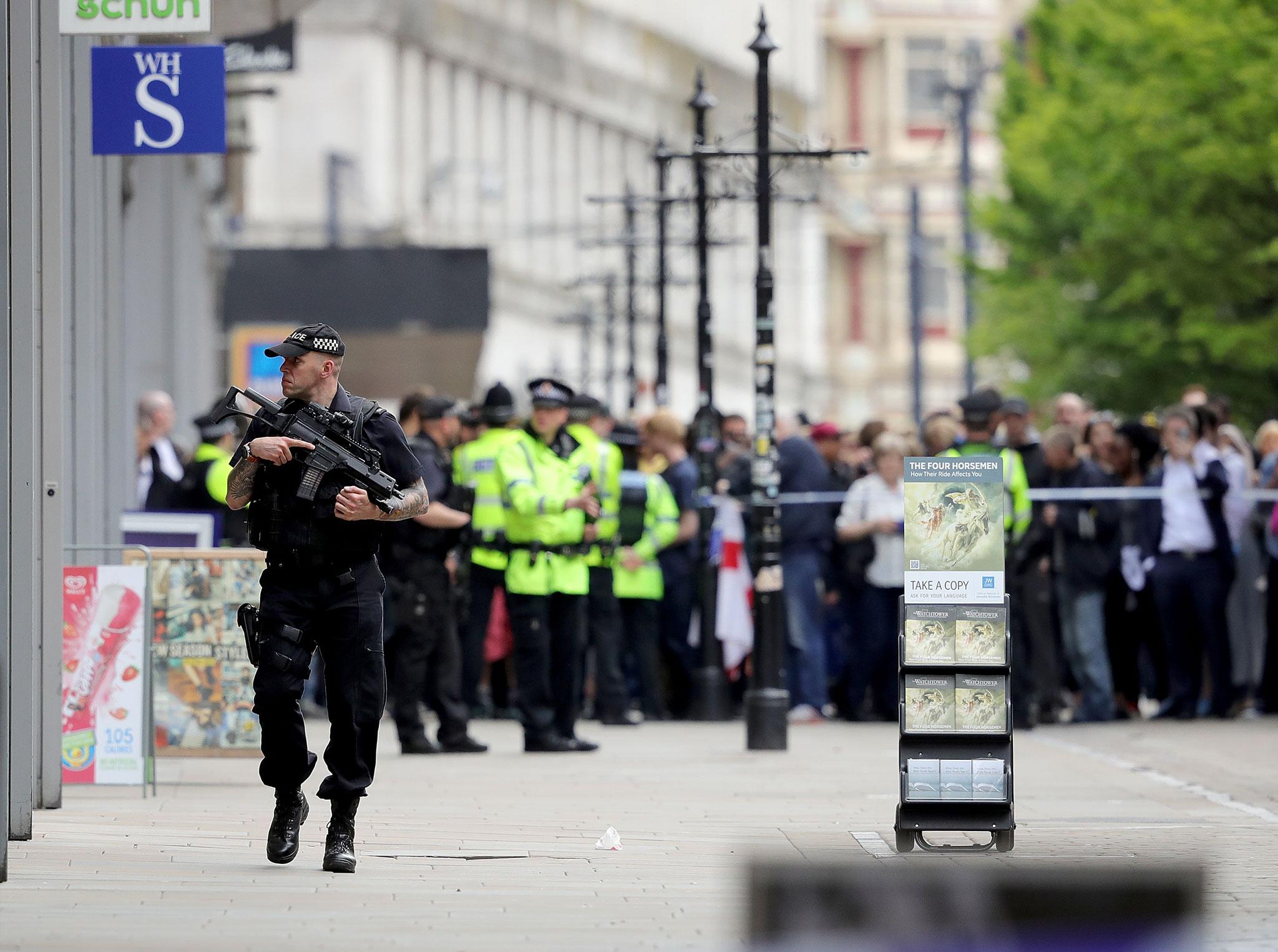 Crowds of people wait outside after police evacuated the Arndale Centre in Manchester/