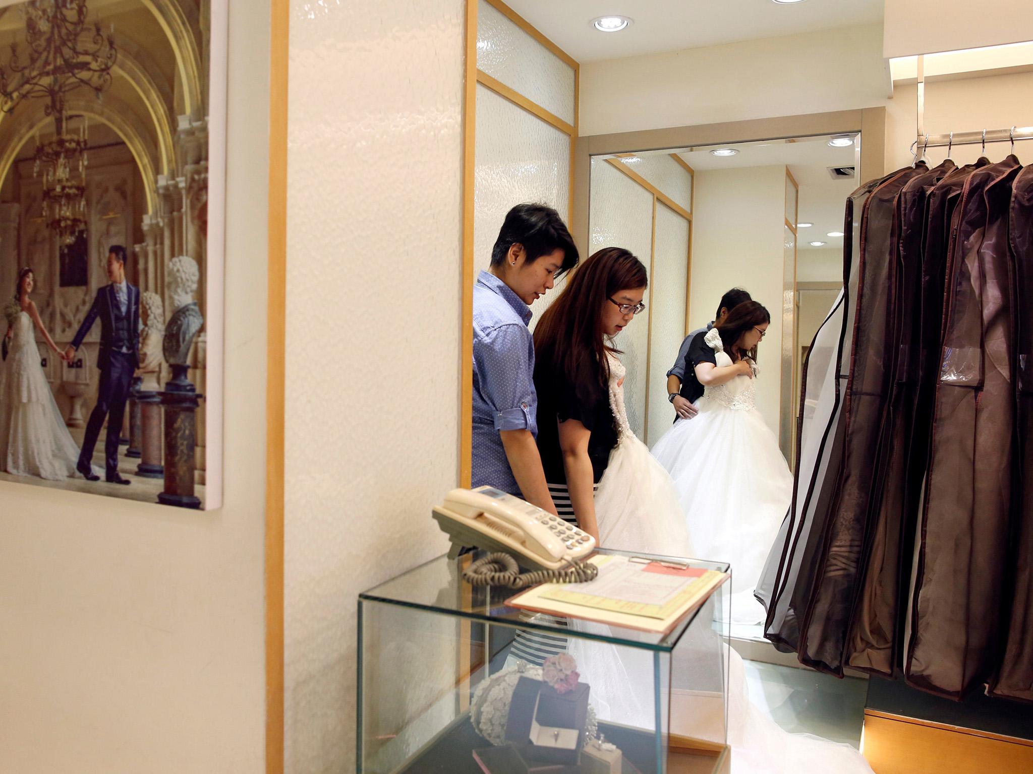 Daphne Chiang (right), an insurance consultant, tries on a wedding dress with her partner Kenny Jhuang, a service worker in Taipei