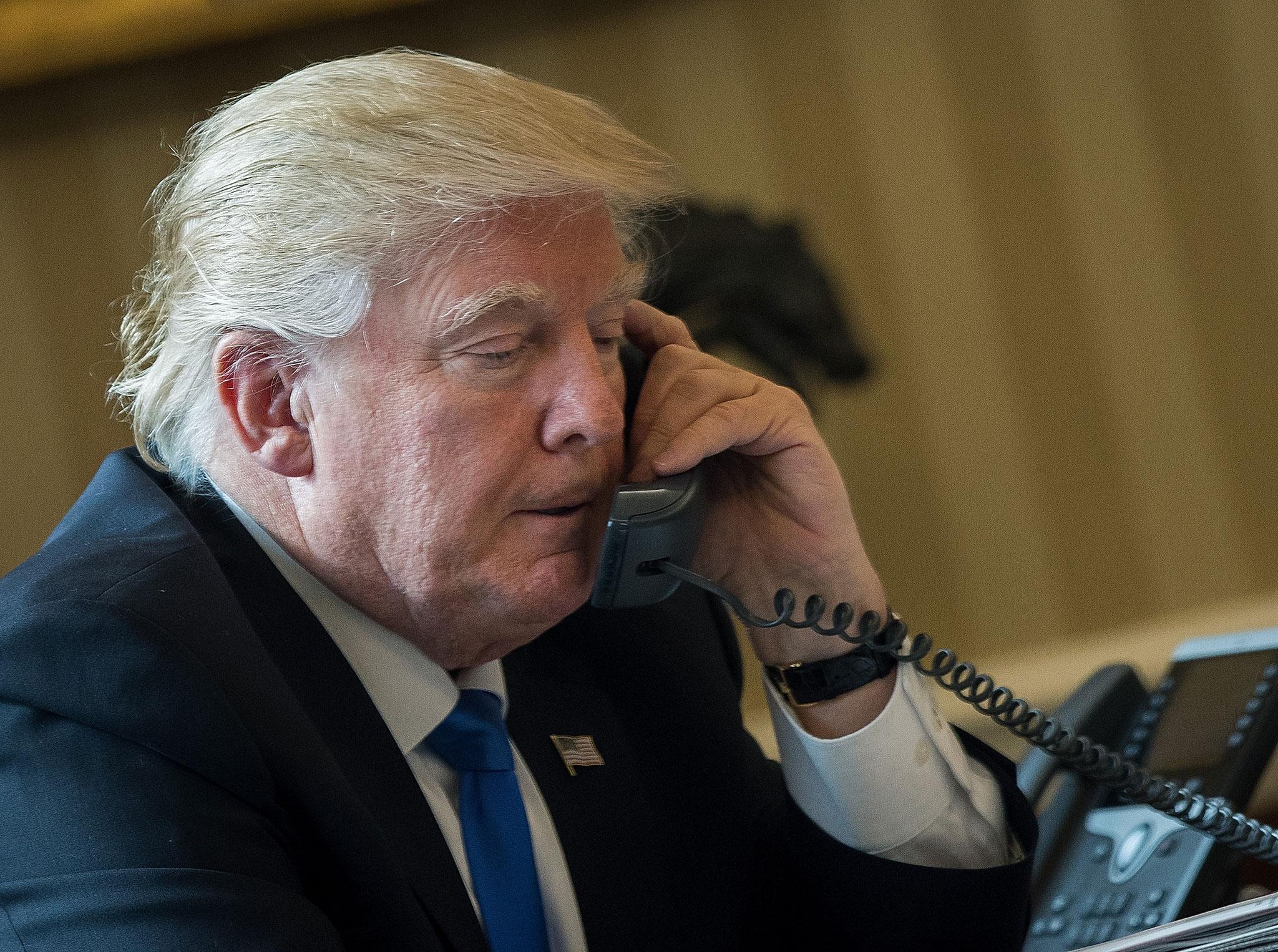 President Donald Trump speaks on the phone with Russian President Vladimir Putin in the Oval Office of the White House