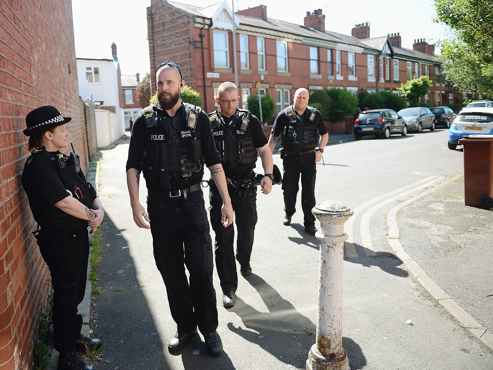 Police officers stand on duty on Dorset Avenue in Moss Side, Manchester, following a raid on a residential property as their investigations continue into the May 22 terror attack at the Manchester Arena