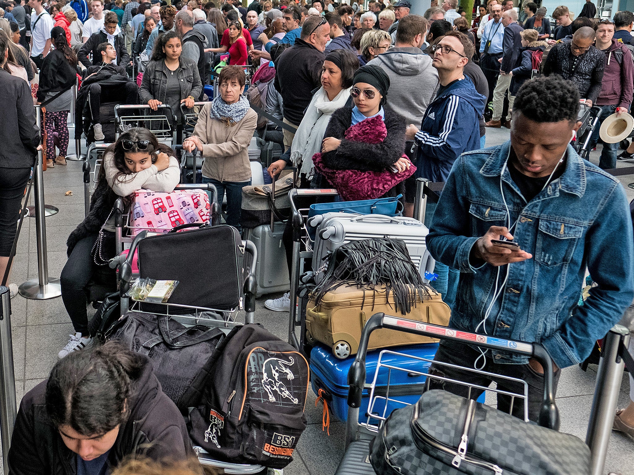 People queue with their luggage outside Heathrow Terminal 5 (Getty)