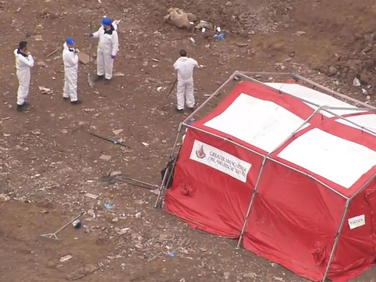 Police staff in forensic suits search a Viridor Waste Management site at Pilsworth, near Bury