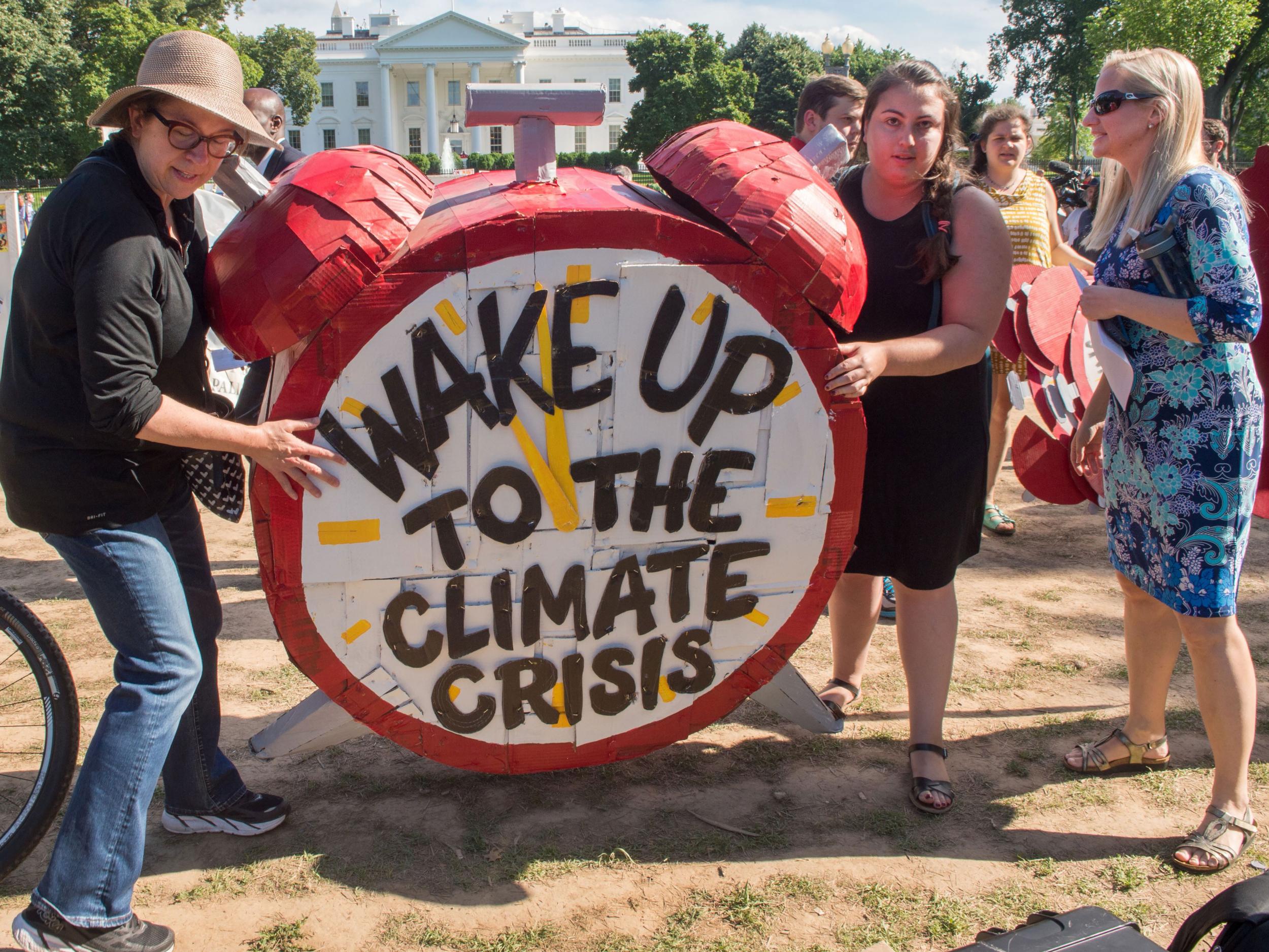 Protesters hold up signs after Trump announces the US withdrawal from the Paris Agreement