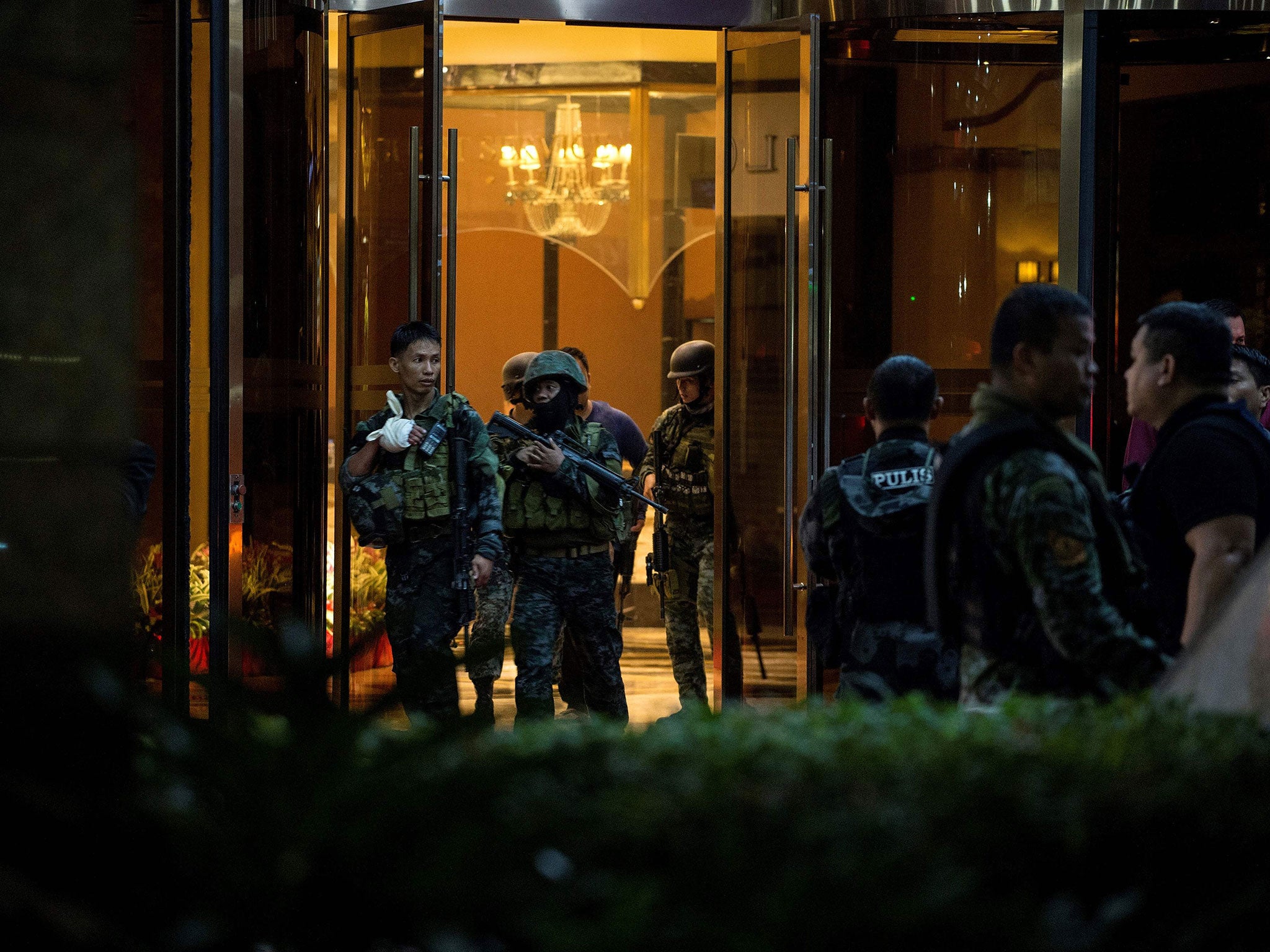 Philippines' police officers come out from the Resorts World Hotel in Manila on Friday following the attack