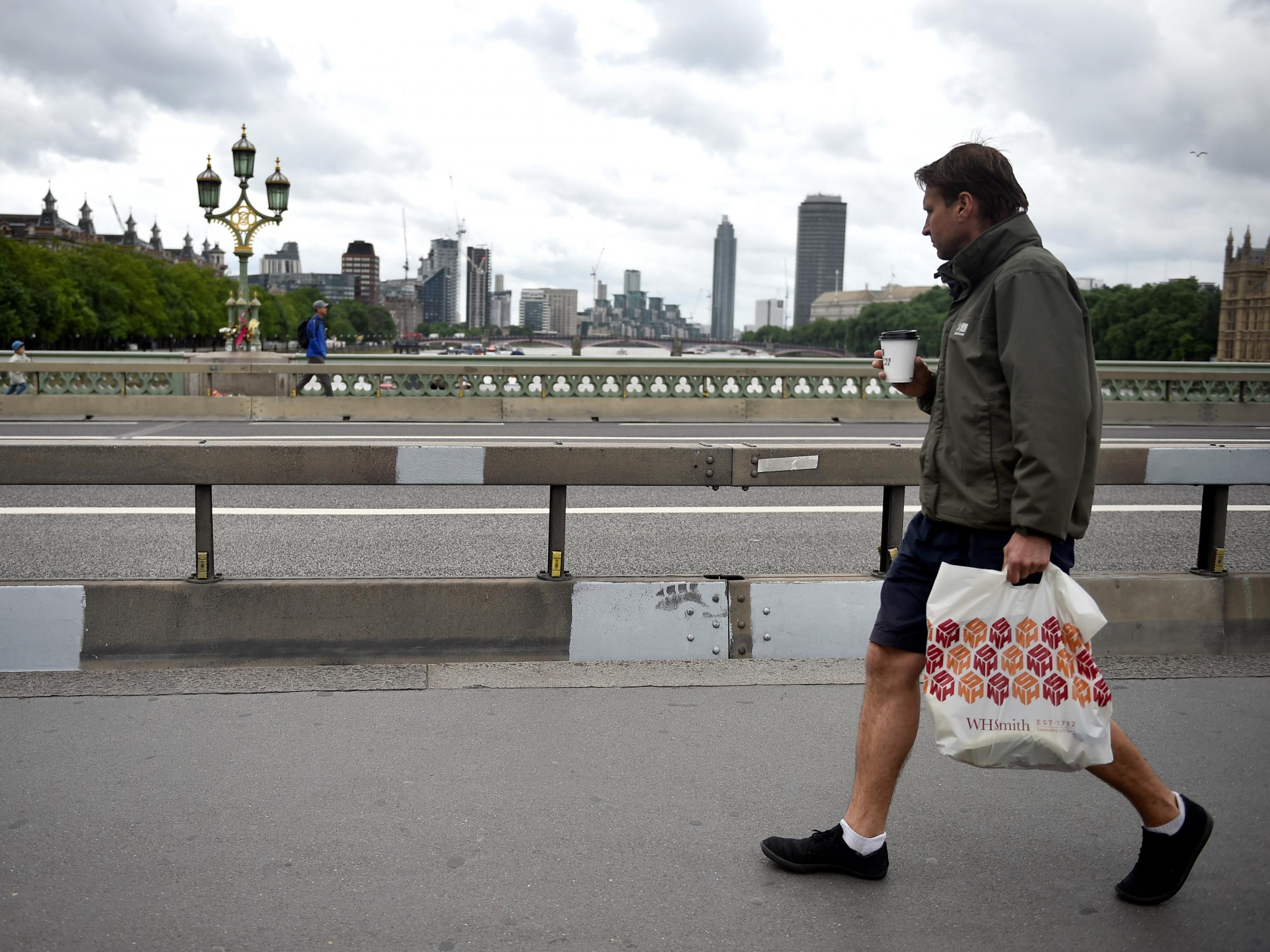 A pedestrian walks past barriers on Westminster Bridge