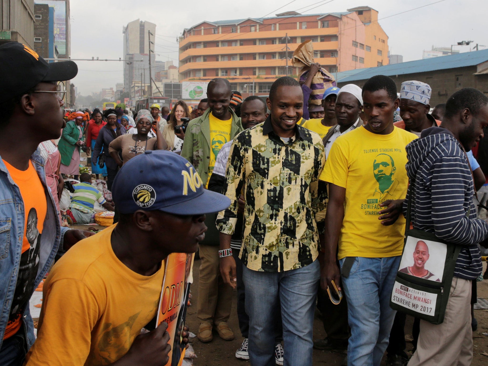 &#13;
Mwangi, centre, is escorted by supporters through downtown Nairobi during his political campaign &#13;