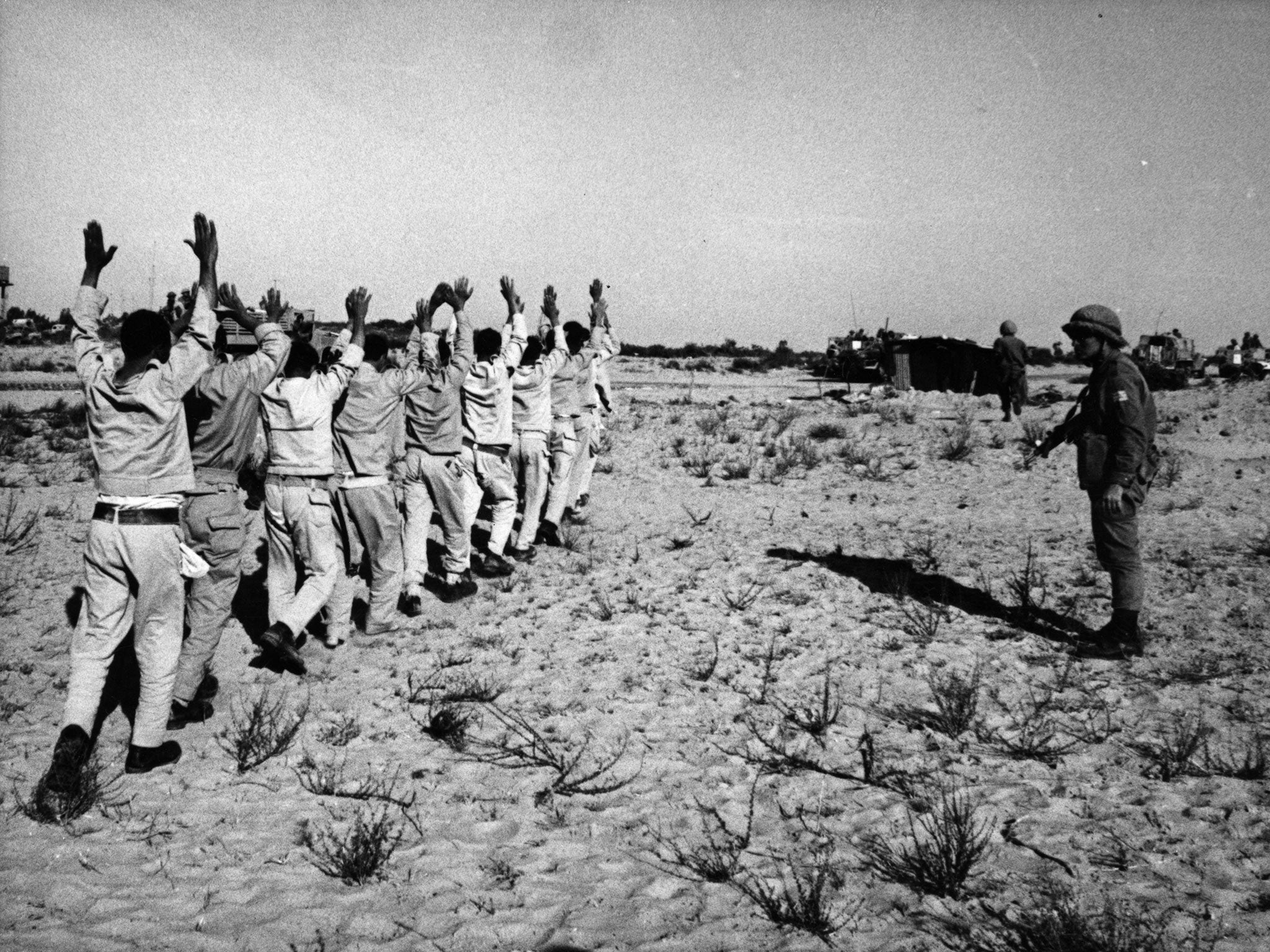 Egyptian prisoners of war holding their hands aloft after being rounded up by Israeli forces in the Sinai desert following the Six-Day War