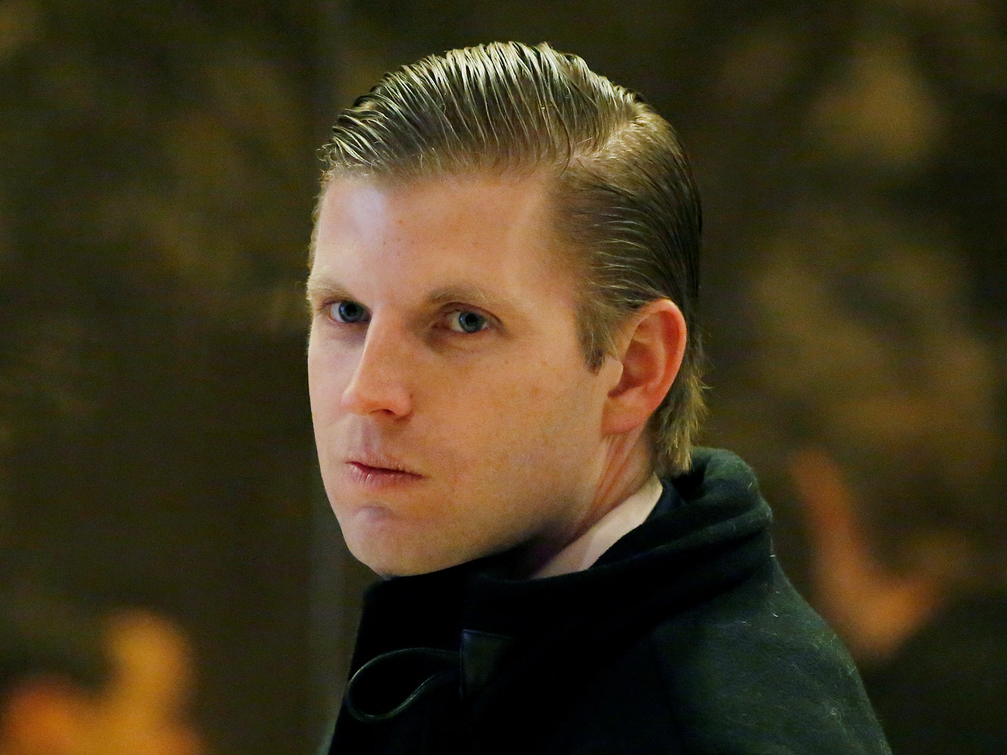 Donald Trump's son Eric Trump waits to enter an escalator in the lobby of Trump Tower in Manhattan