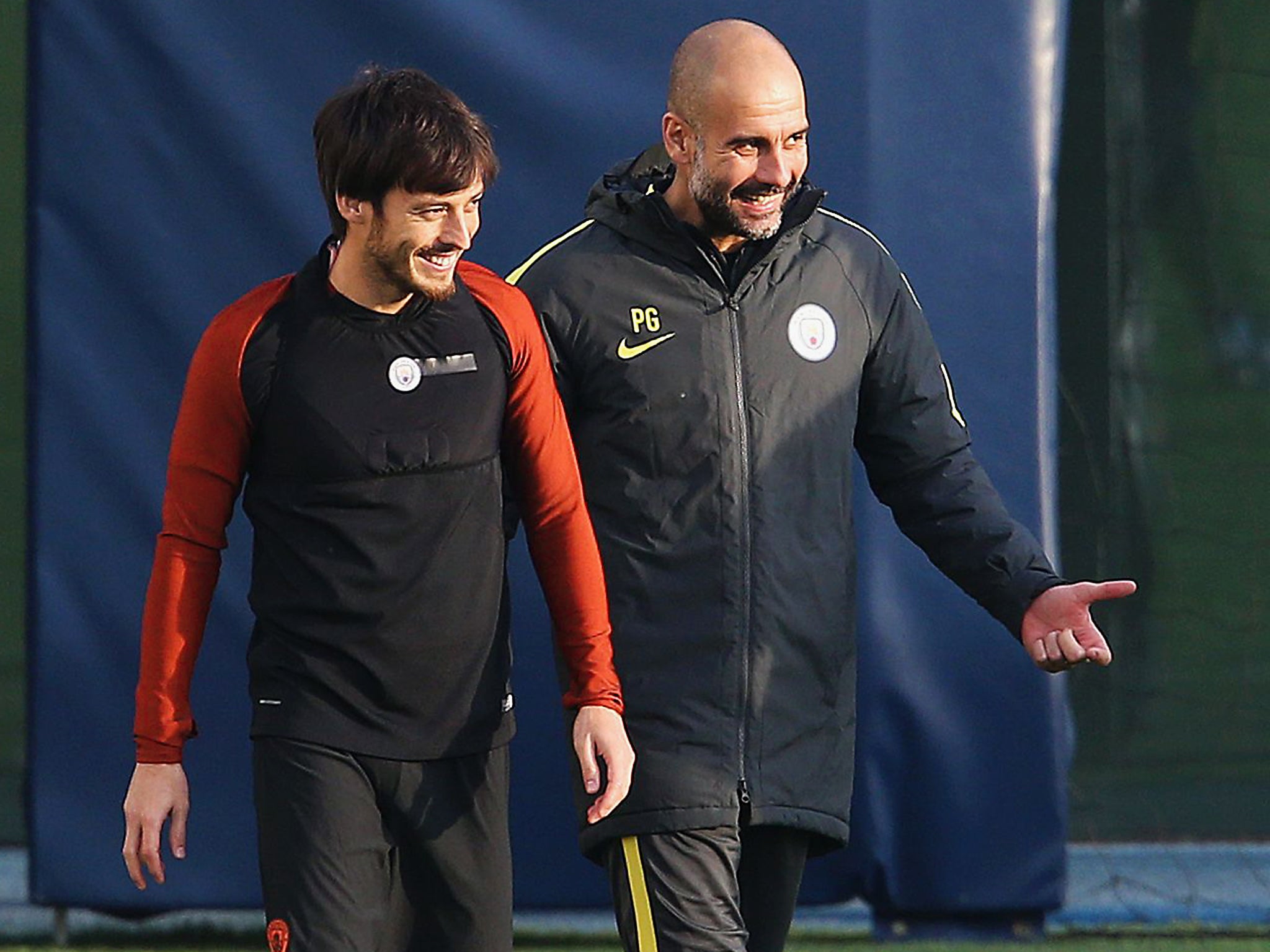 Manchester City manager Pep Guardiola talks with David Silva during a training session