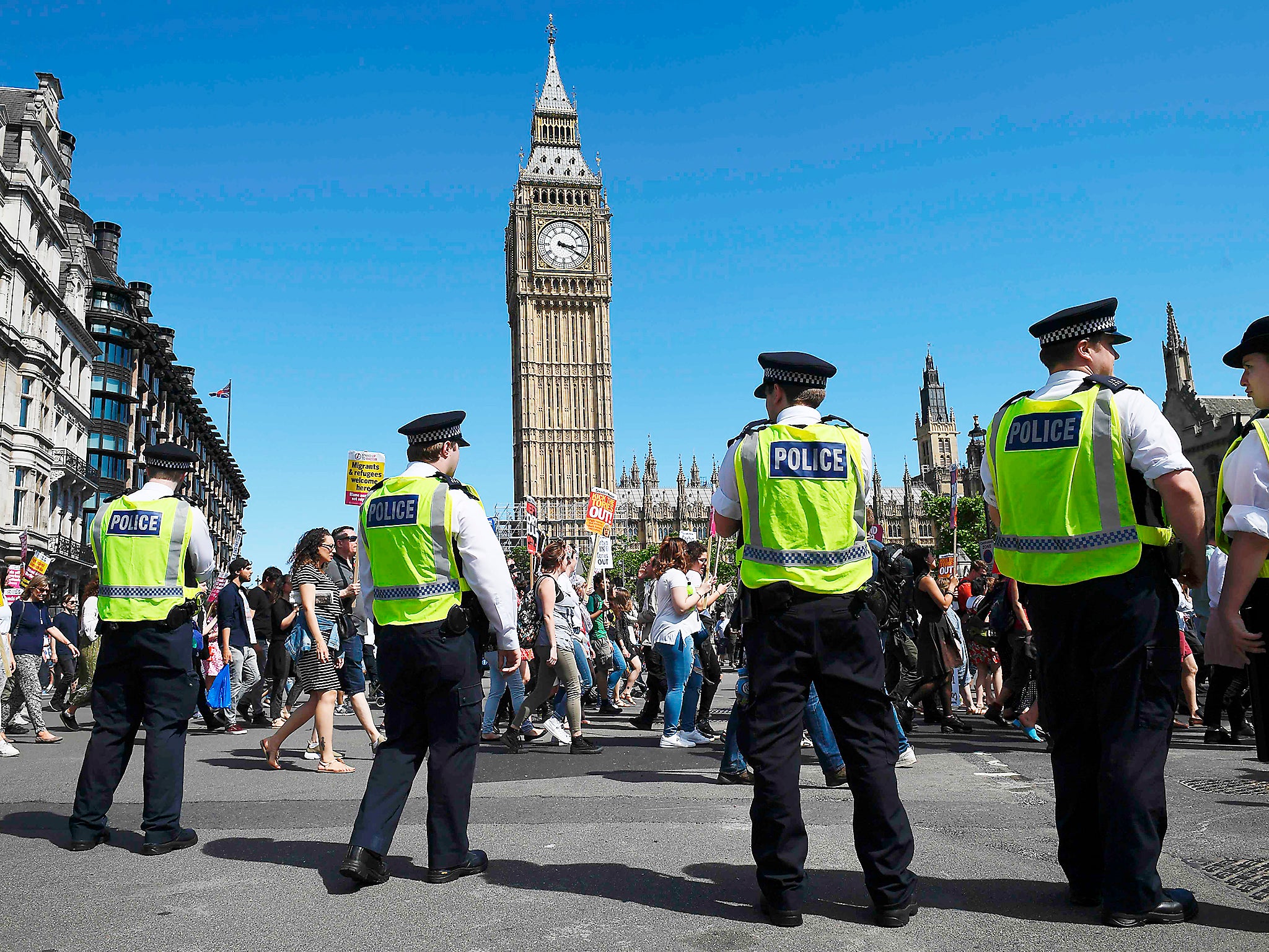 &#13;
Police officers monitor as protesters with anti-Conservative Party and anti-DUP placards march into Parliament Square in front of the Houses of Parliament from Whitehall in central London &#13;