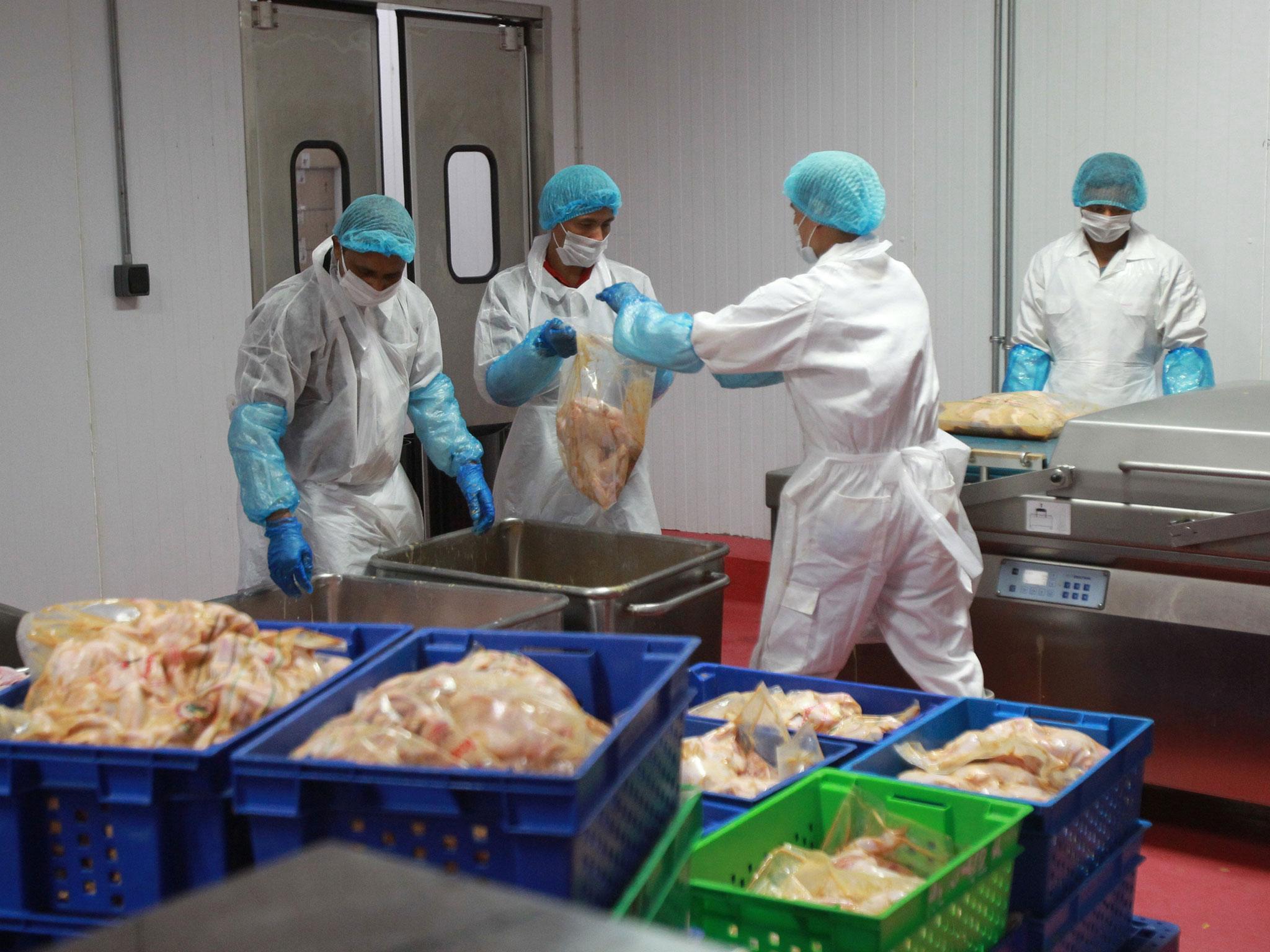 Workers work in a meat processing plant in Doha, Qatar