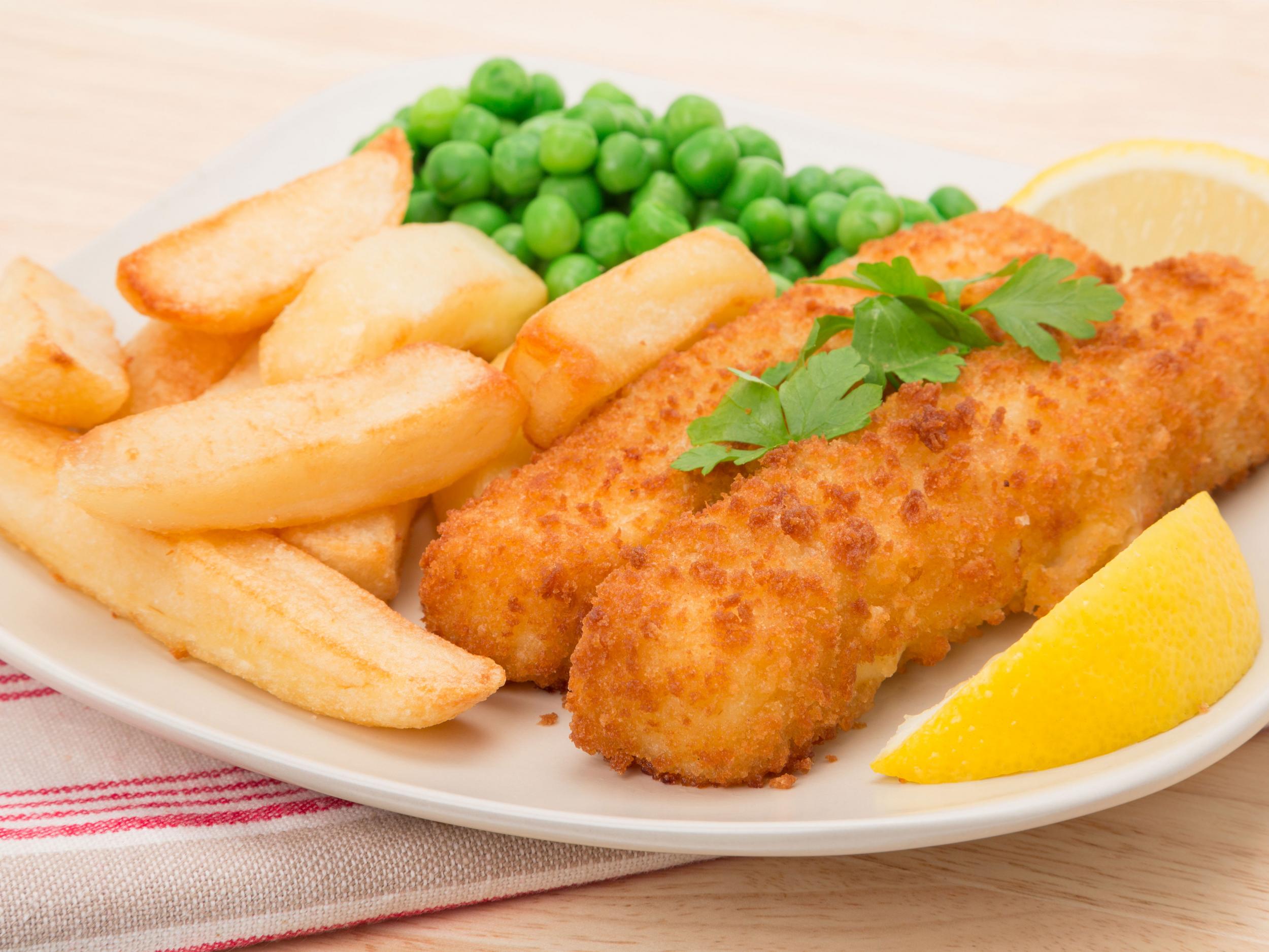 Stock image of fish fingers, chips and peas on a plate