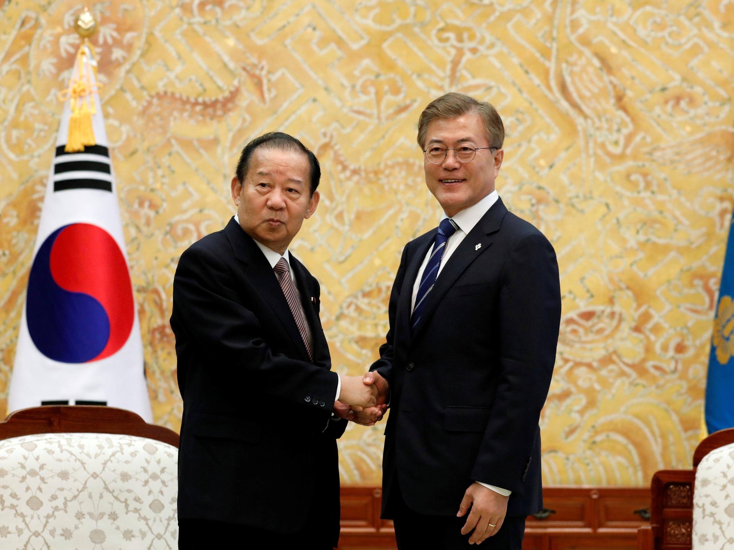 South Korean President Moon Jae-in (right) shakes hands with Toshihiro Nikai, Secretary General of the Japanese Liberal Democratic Party, during their meeting at the Presidential Blue House in Seoul