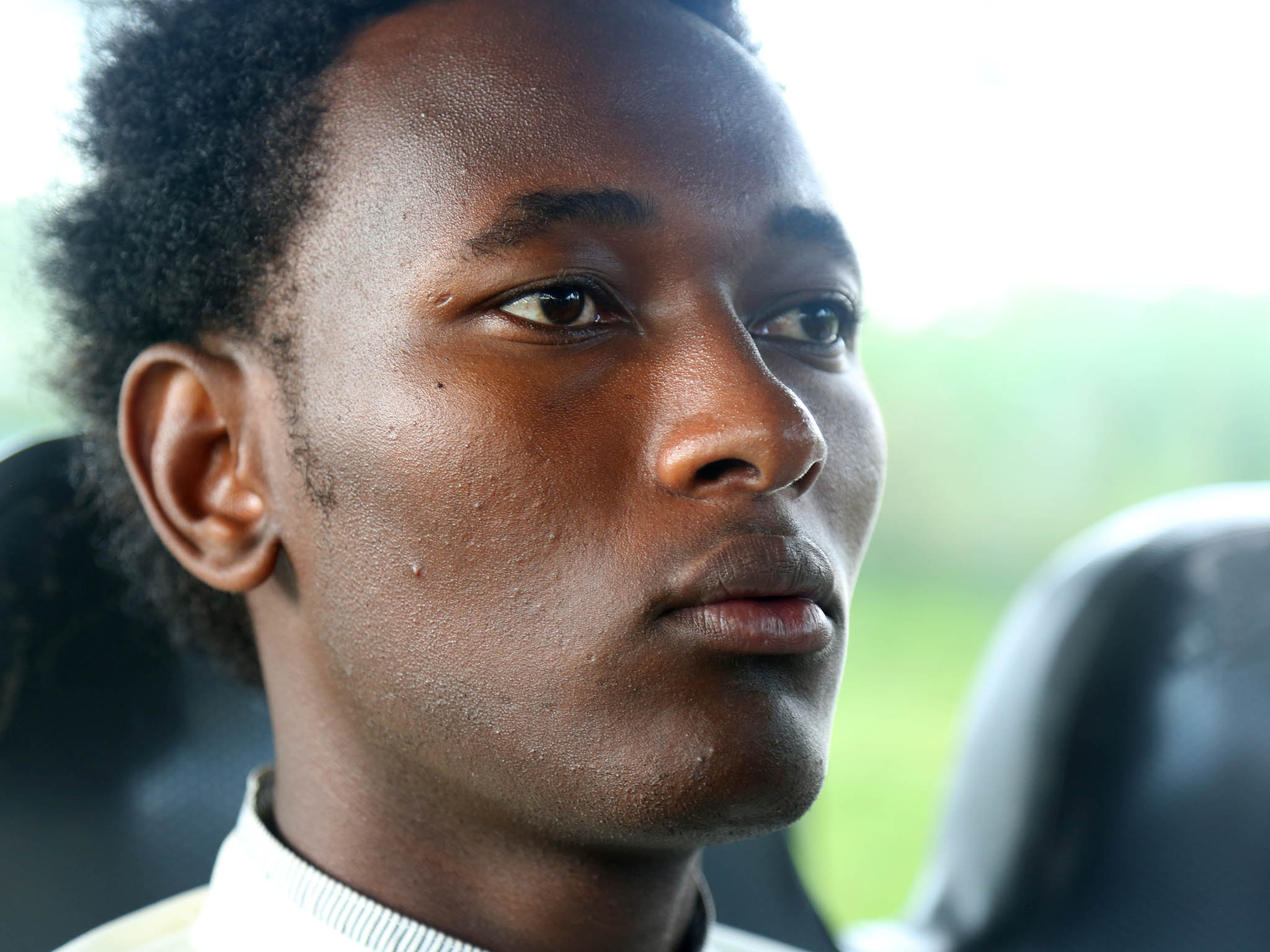 Albert, who declined to use his last name because of the stigma surrounding his situation, rides the bus from Huye to Kigali