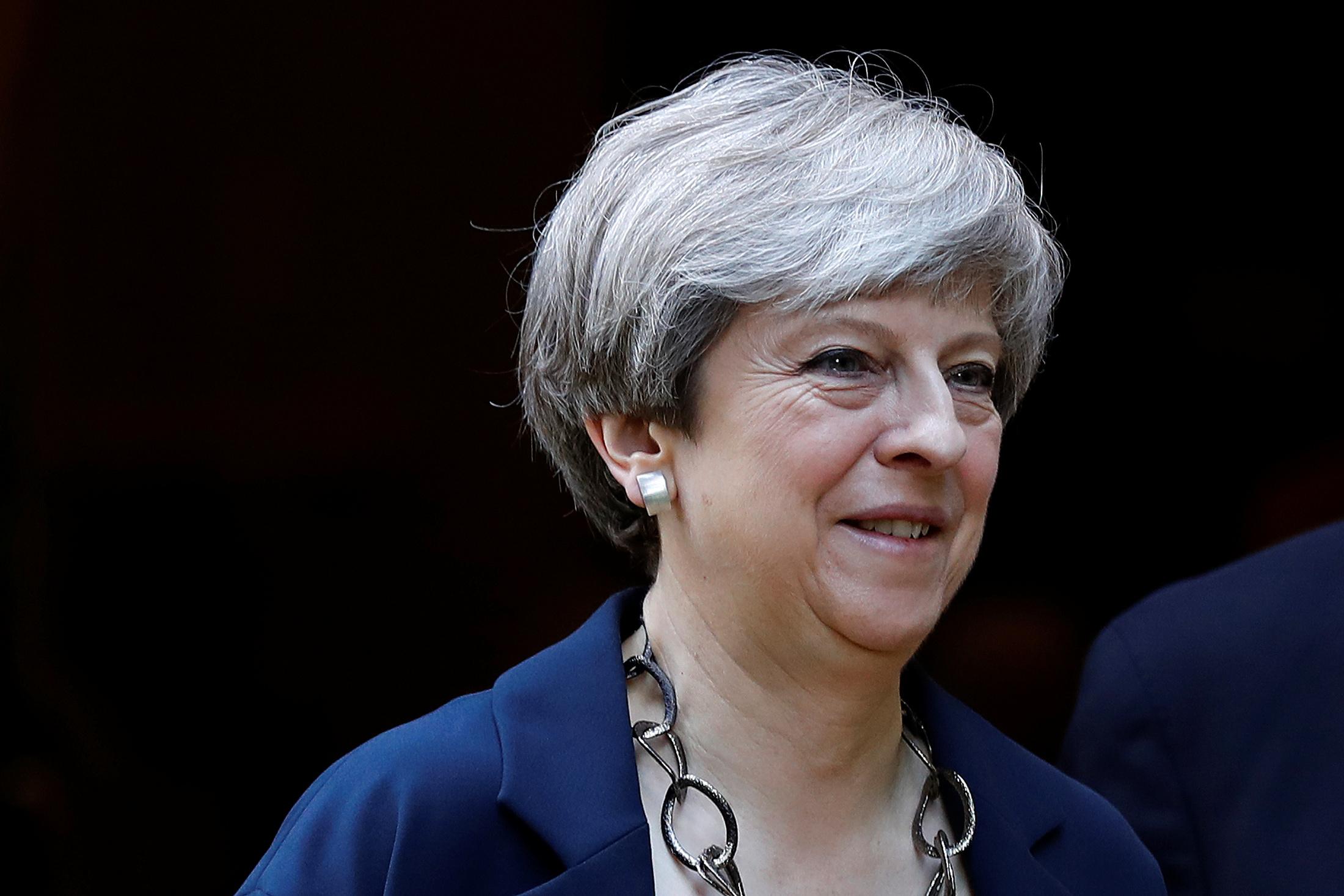 Minister Theresa May leaves after a church service in Sonning, Britain