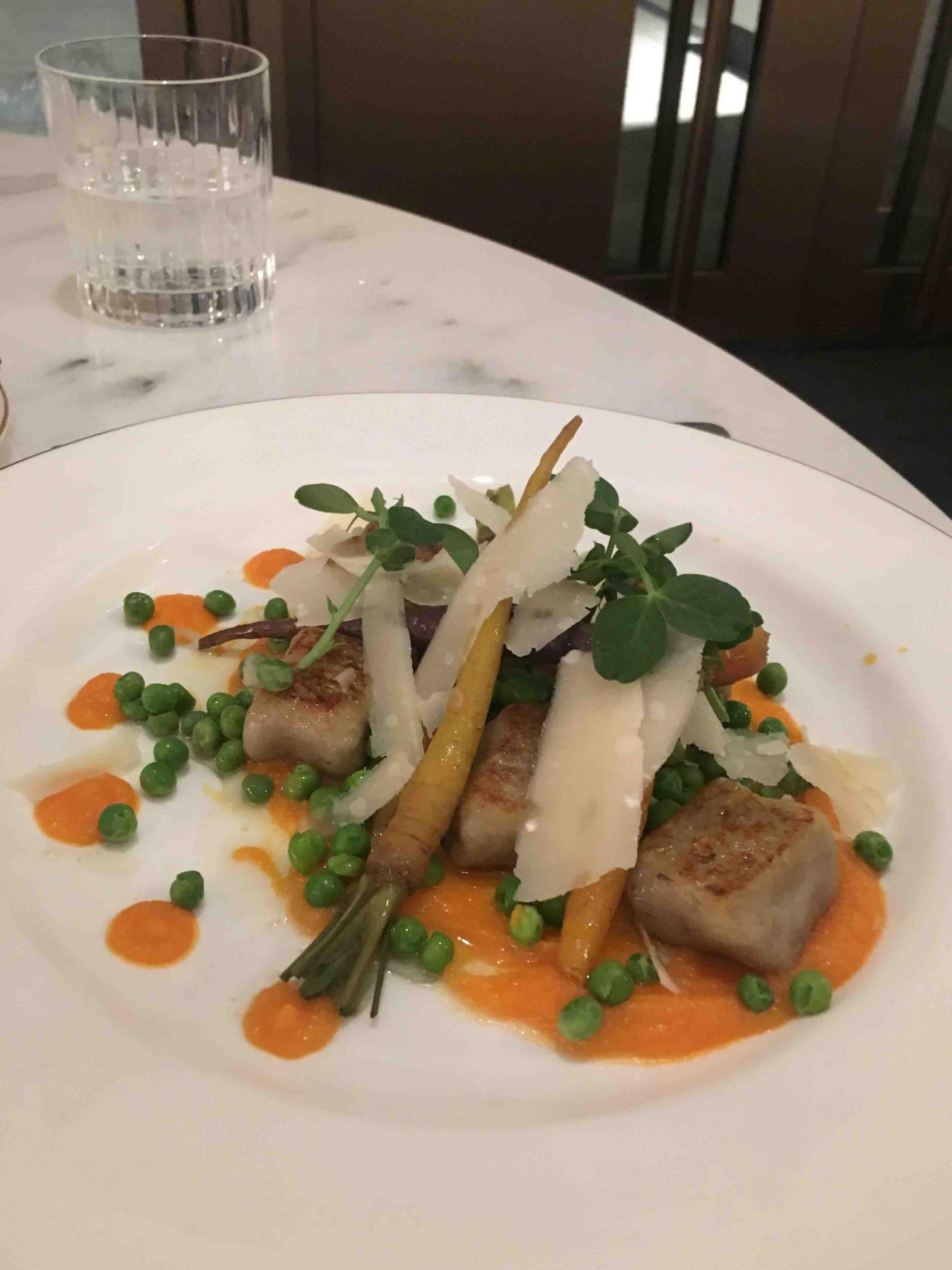 A plate of gnocchi came served on orange smears of pureed veg