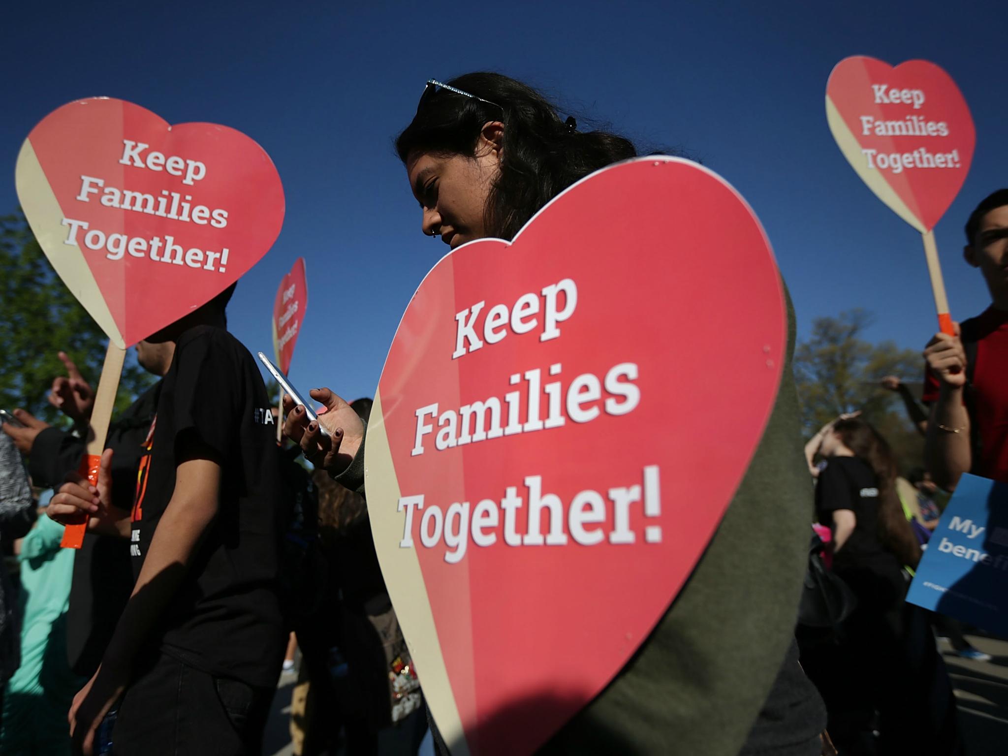 Pro-immigration activists hold signs as they gather in front of the US Supreme Court on 18 April 2016 in Washington, DC