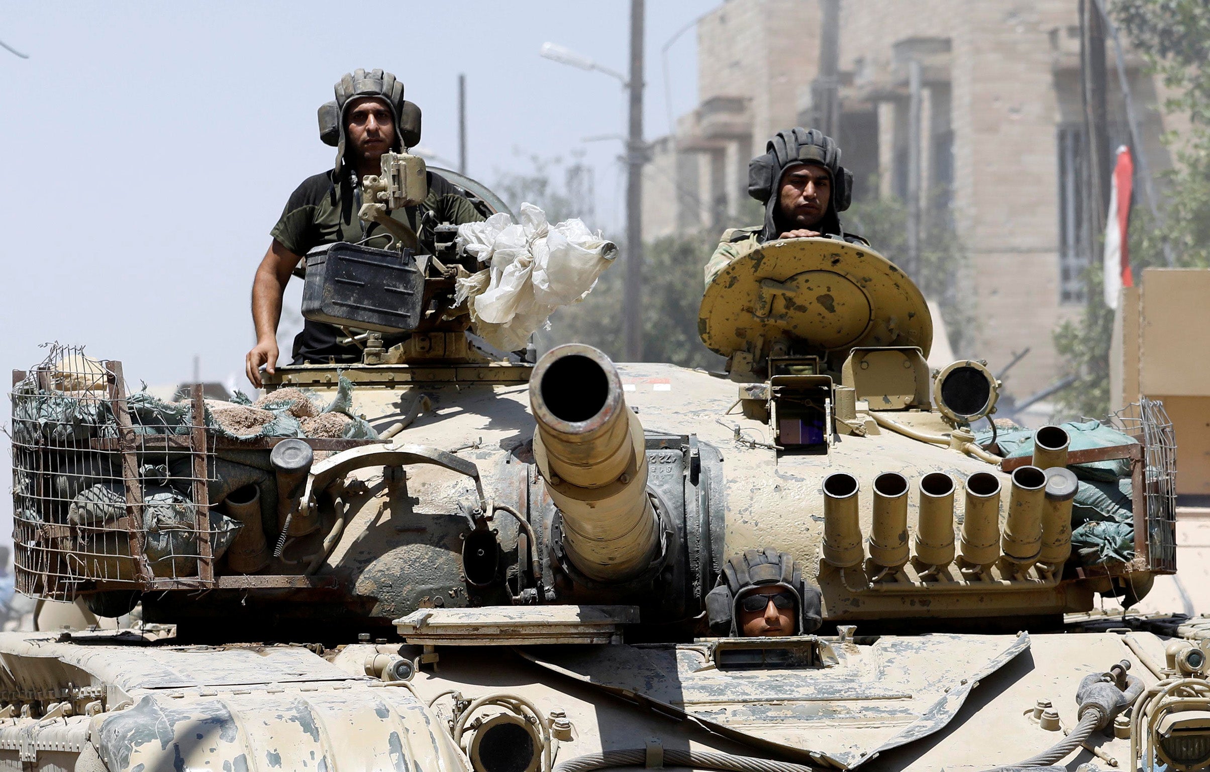 Iraqi soldiers look out from a tank as they advances towards the Isis positions