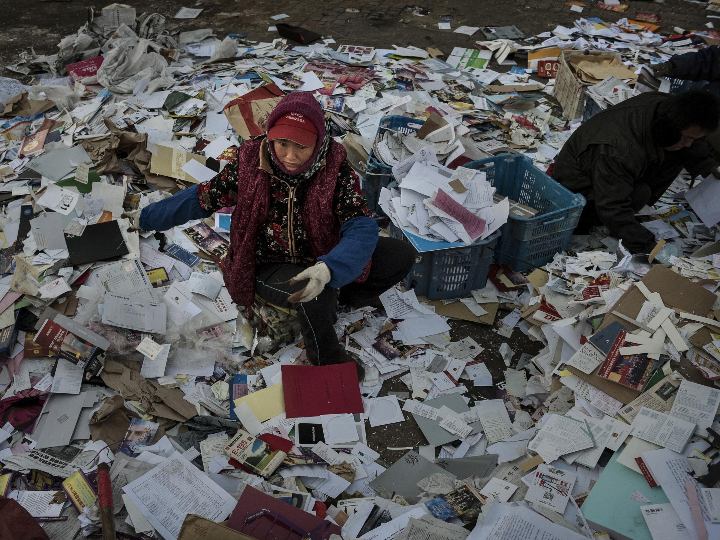 Migrant workers sorting paper in Beijing. Millions have come to the cities in search of a better life but end up living in cramped conditions with little rights