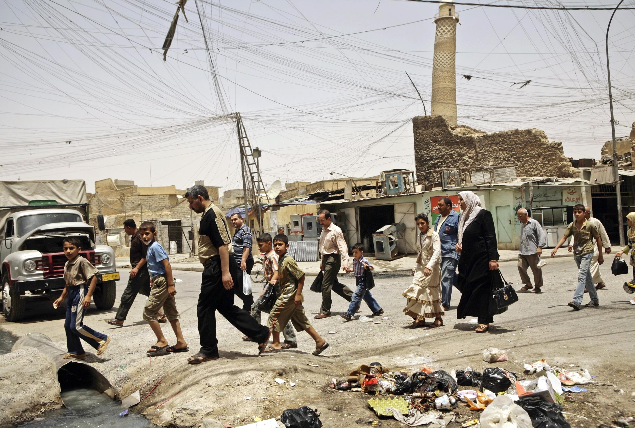 The famous mosque is seen behind this crowd in Mosul