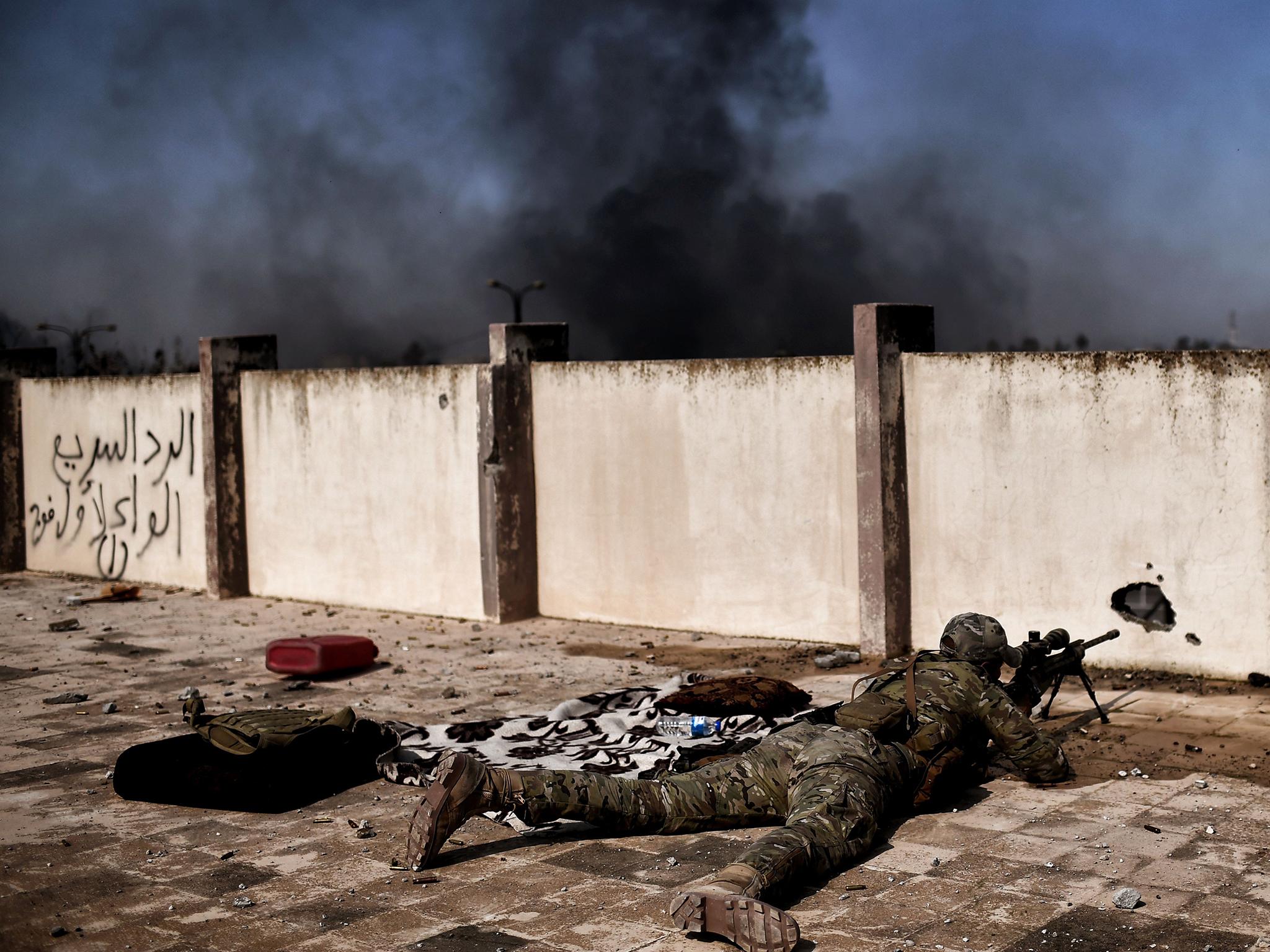 A sniper fires at targets during clashes with Islamic State group fighters in Mosul