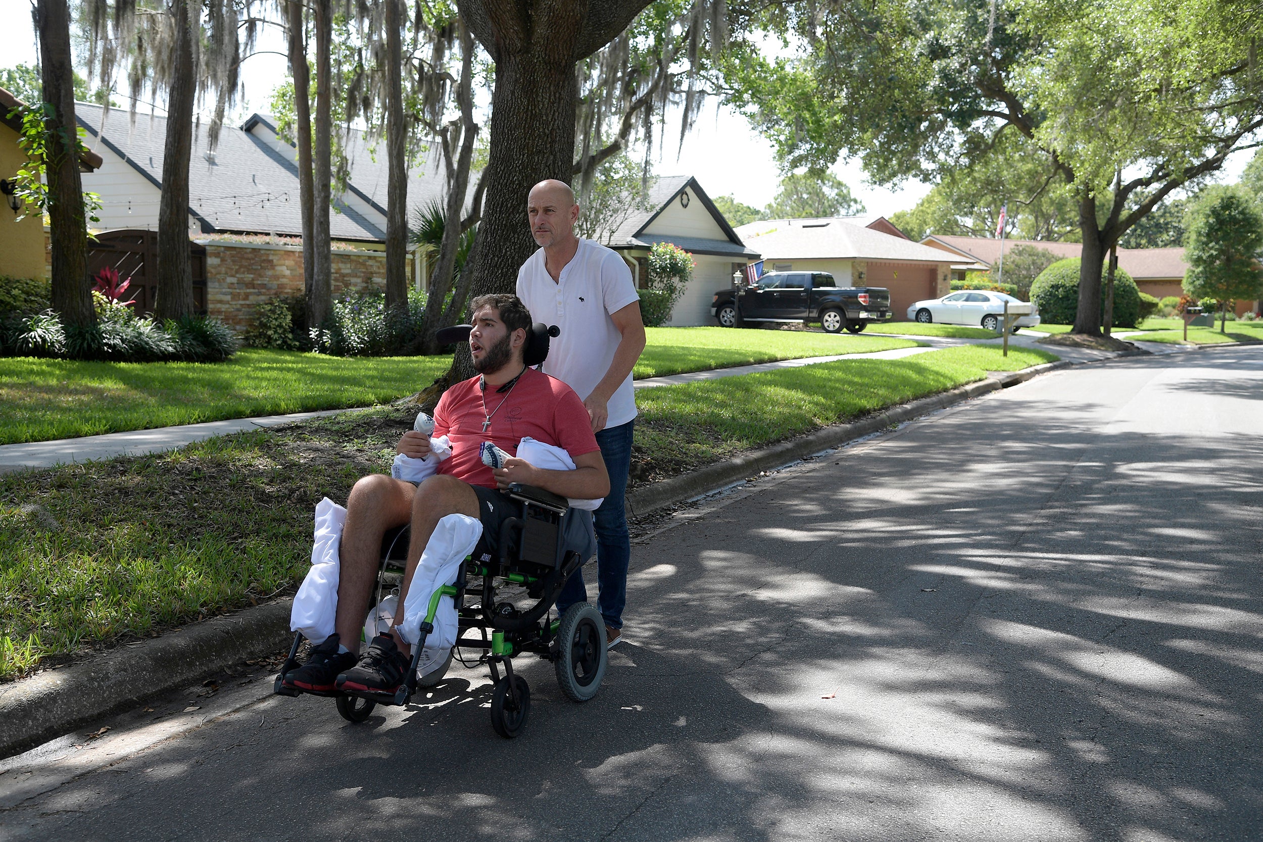 Richard Colón takes his son, Prichard Colón, on a stroll around their neighborhood. The younger Colón remains in a vegetative state after suffering a traumatic brain injury during his bout against Terrel Williams