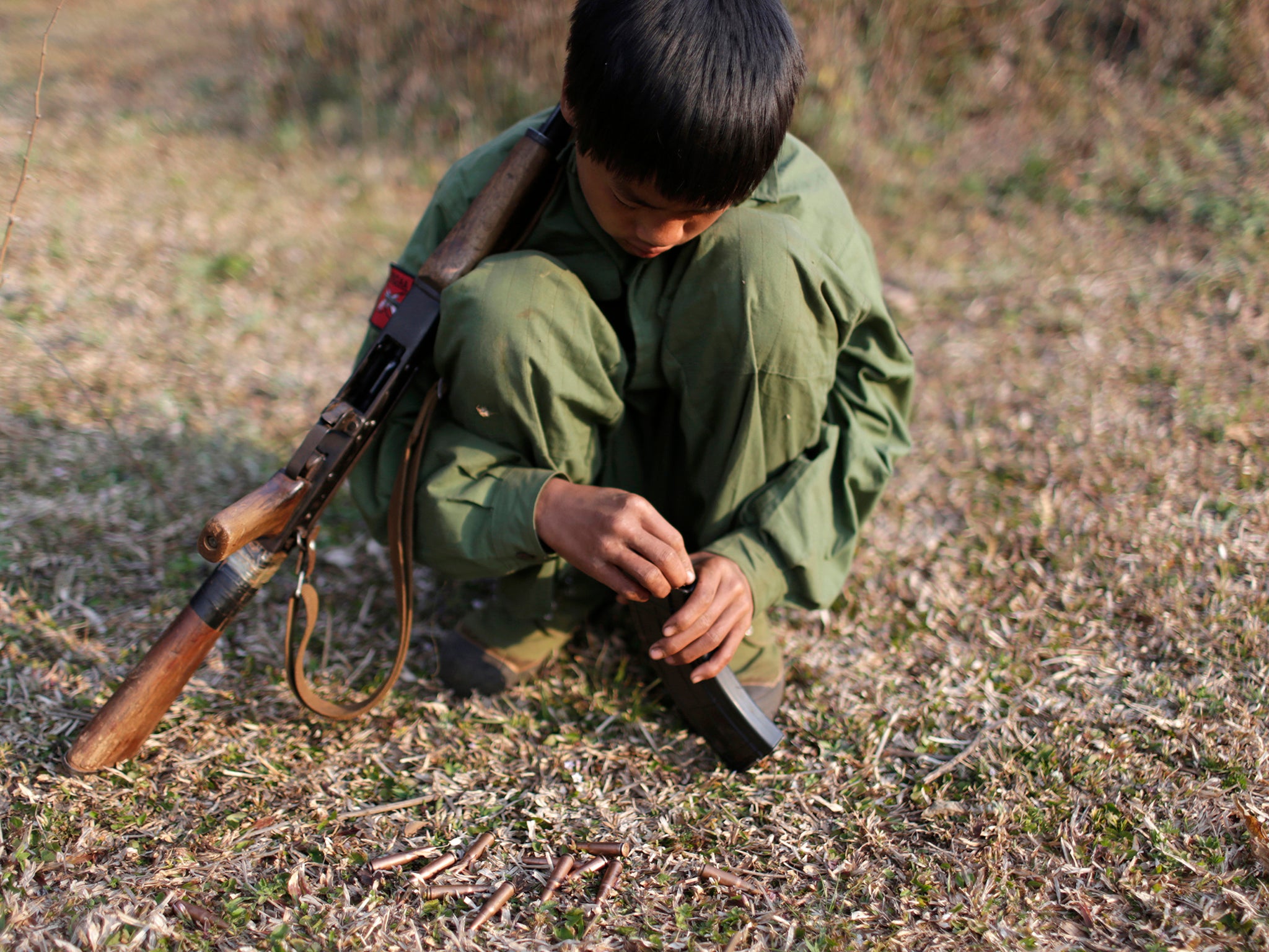 A 15-year-old rebel soldier of the Myanmar National Democratic Alliance Army inserts bullets into the clip of his rifle near a military base in Kokang region. Pictured 2015.