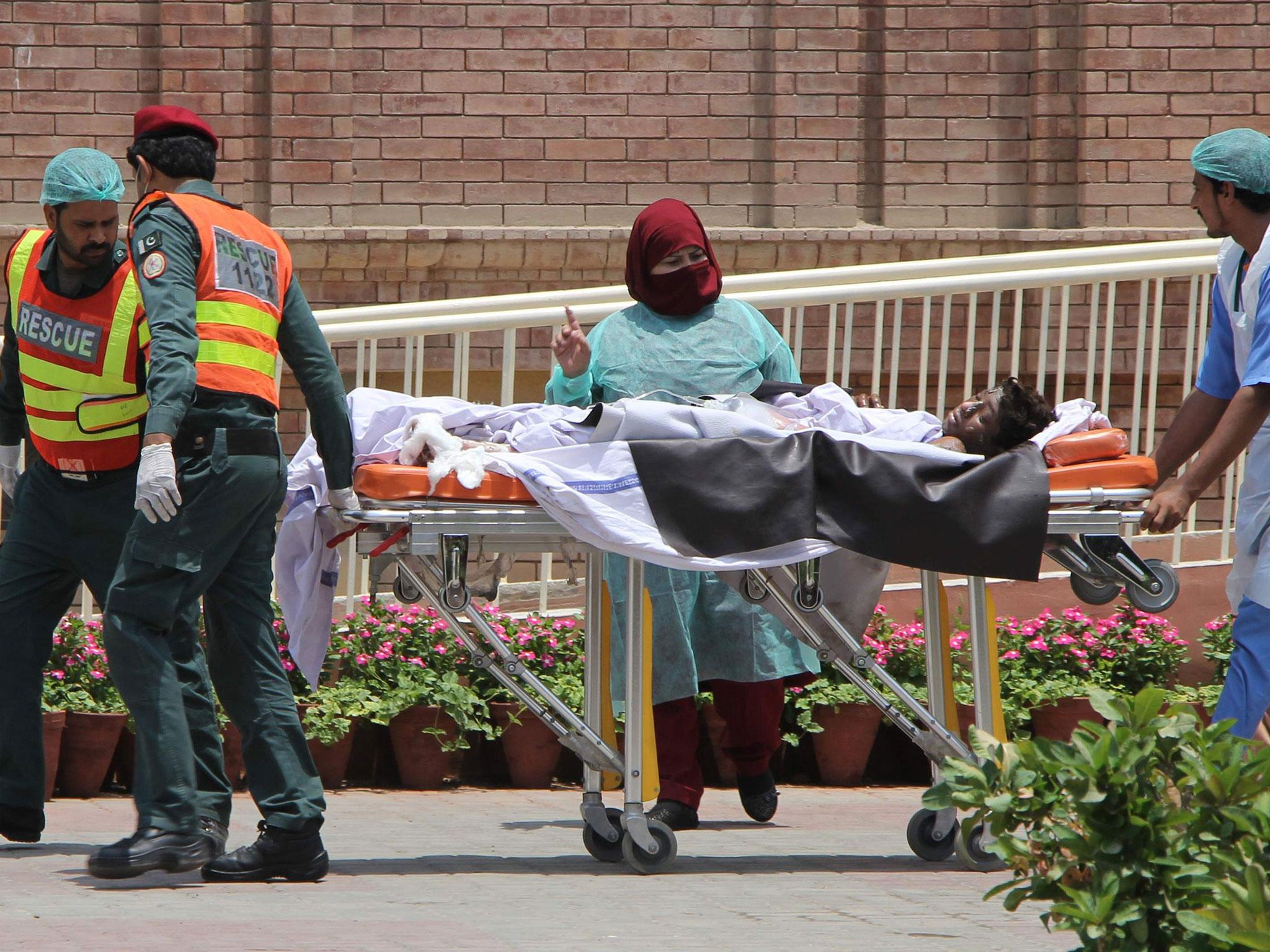 Pakistani rescue workers and paramedics bring a burns victim to a hospital in Multan (Mansoor Abbas/AFP/Getty Images)