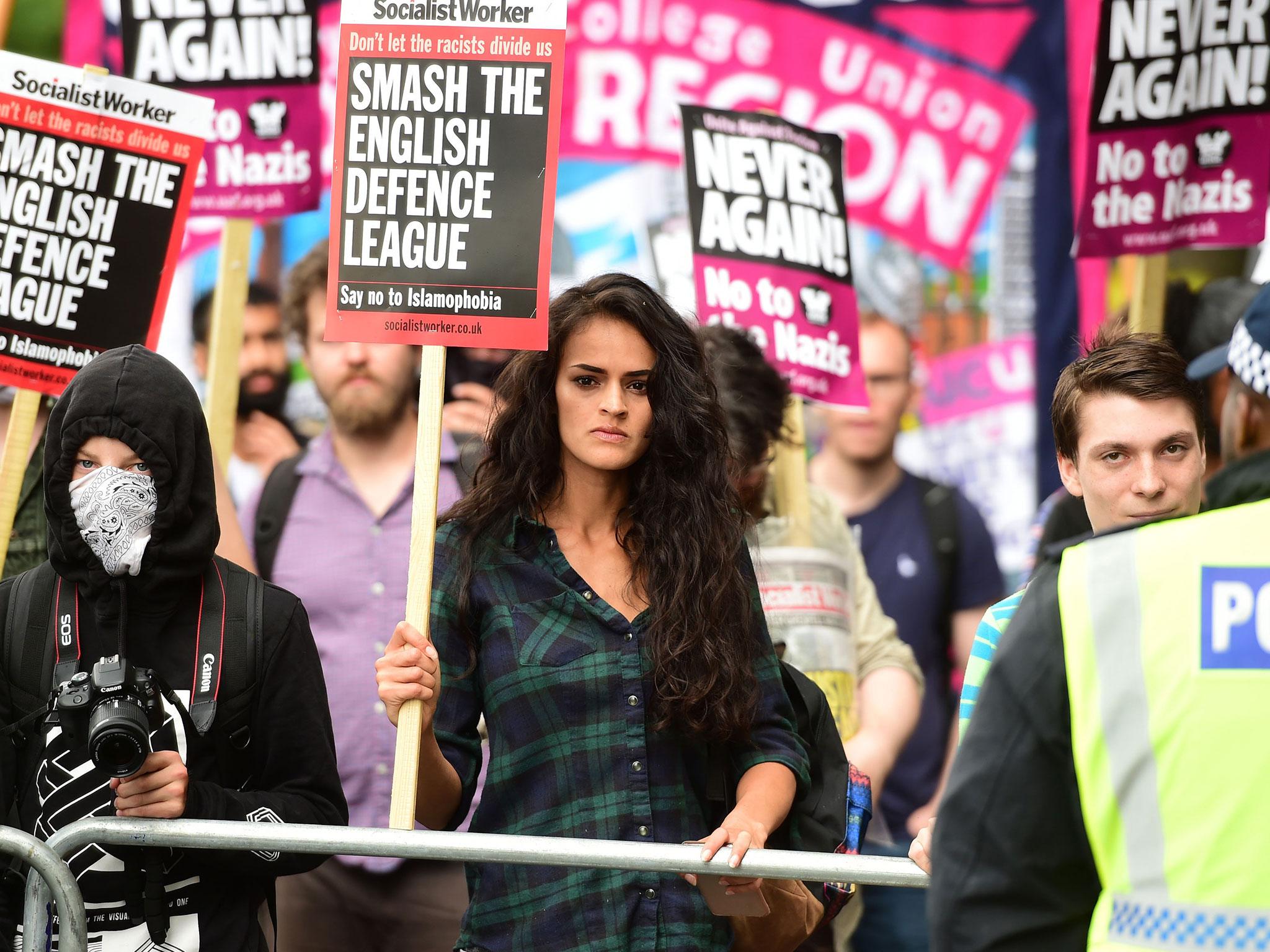 People protest against the English Defence League (EDL) in central London, with one woman holding a Socialist Worker placard reading 'Don't let the fascists divide us, smash the English defence league, say no to Islamophobia