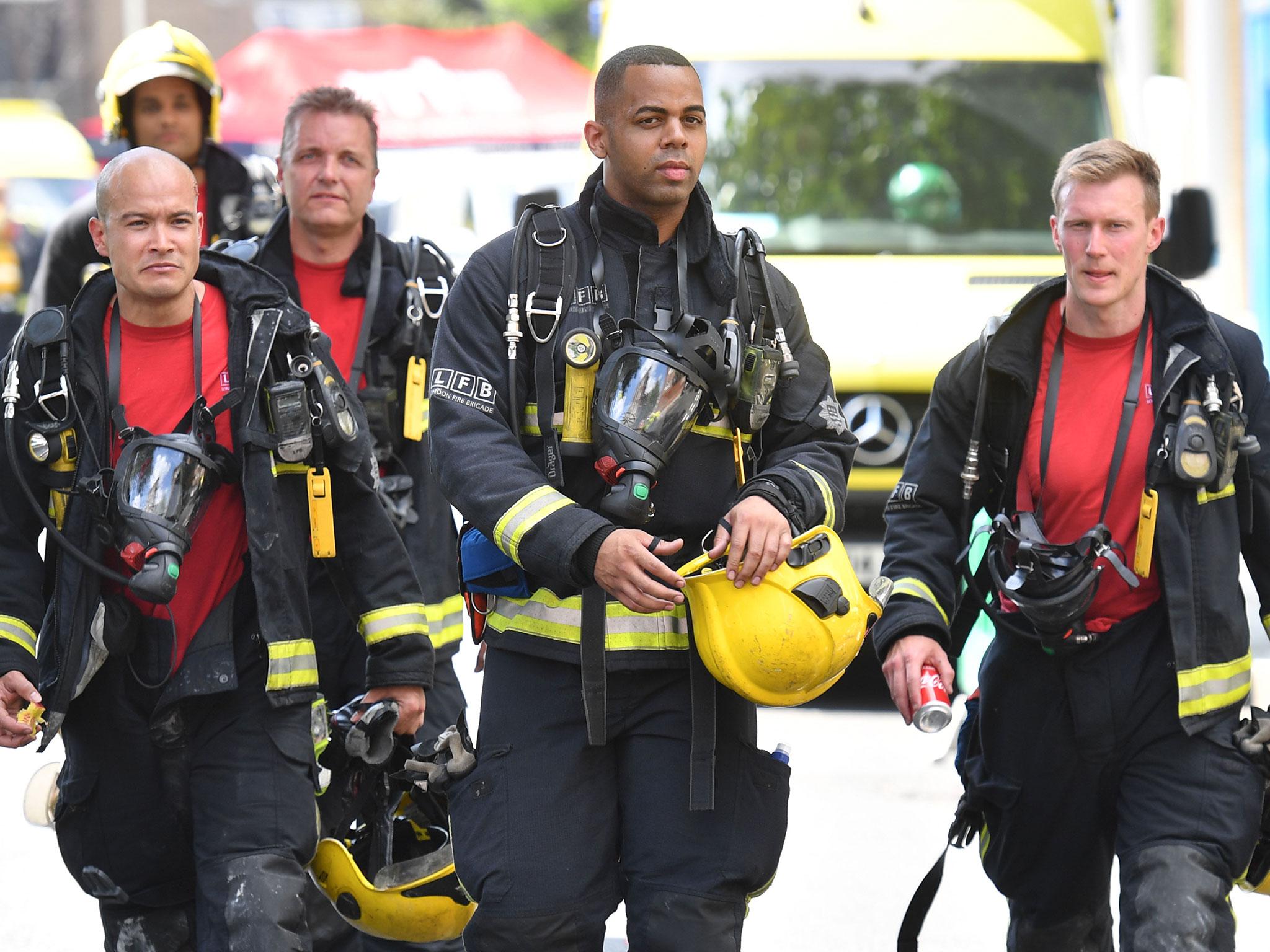 Firefighters work at the scene where a fire ripped through Grenfell Tower, on June 14, 2017