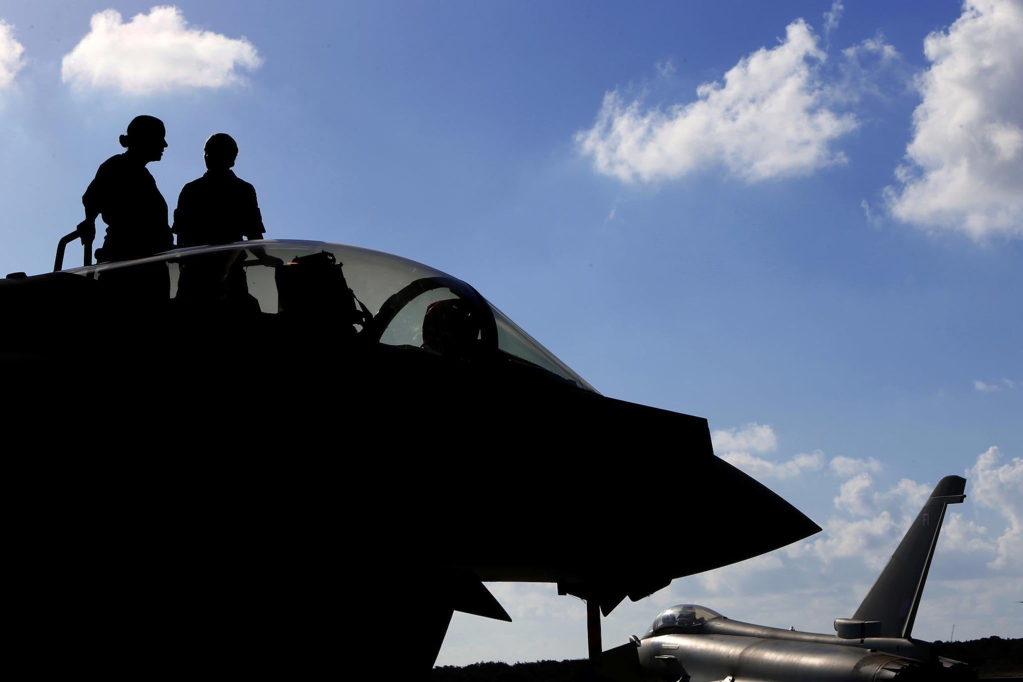 This photo taken on September 22, 2016 shows a British soldiers standing on a Britain's Royal Air Force Eurofighter Typhoon fighter jet before taking off from RAF's Akrotiri base in Cyprus, for a coalition mission over Iraq