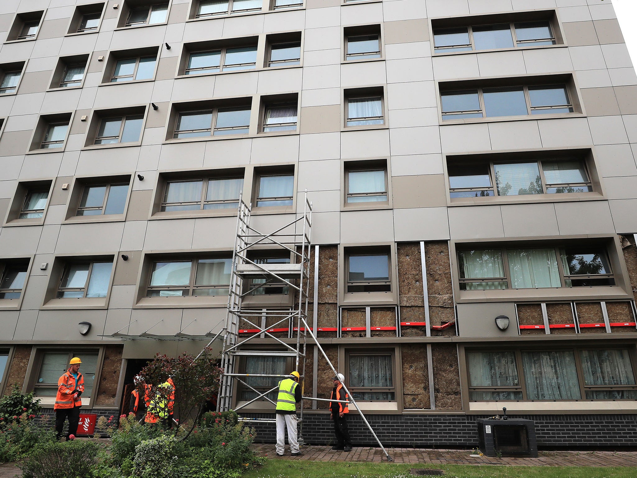 Workers remove cladding from Hornchurch Court, a block in Hulme, Manchester