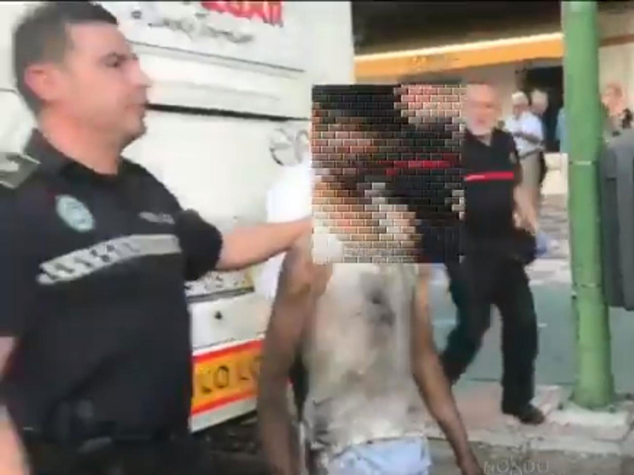 A boy being taken from the underside of a tourist coach from Morocco in Seville, Spain, on 26 June