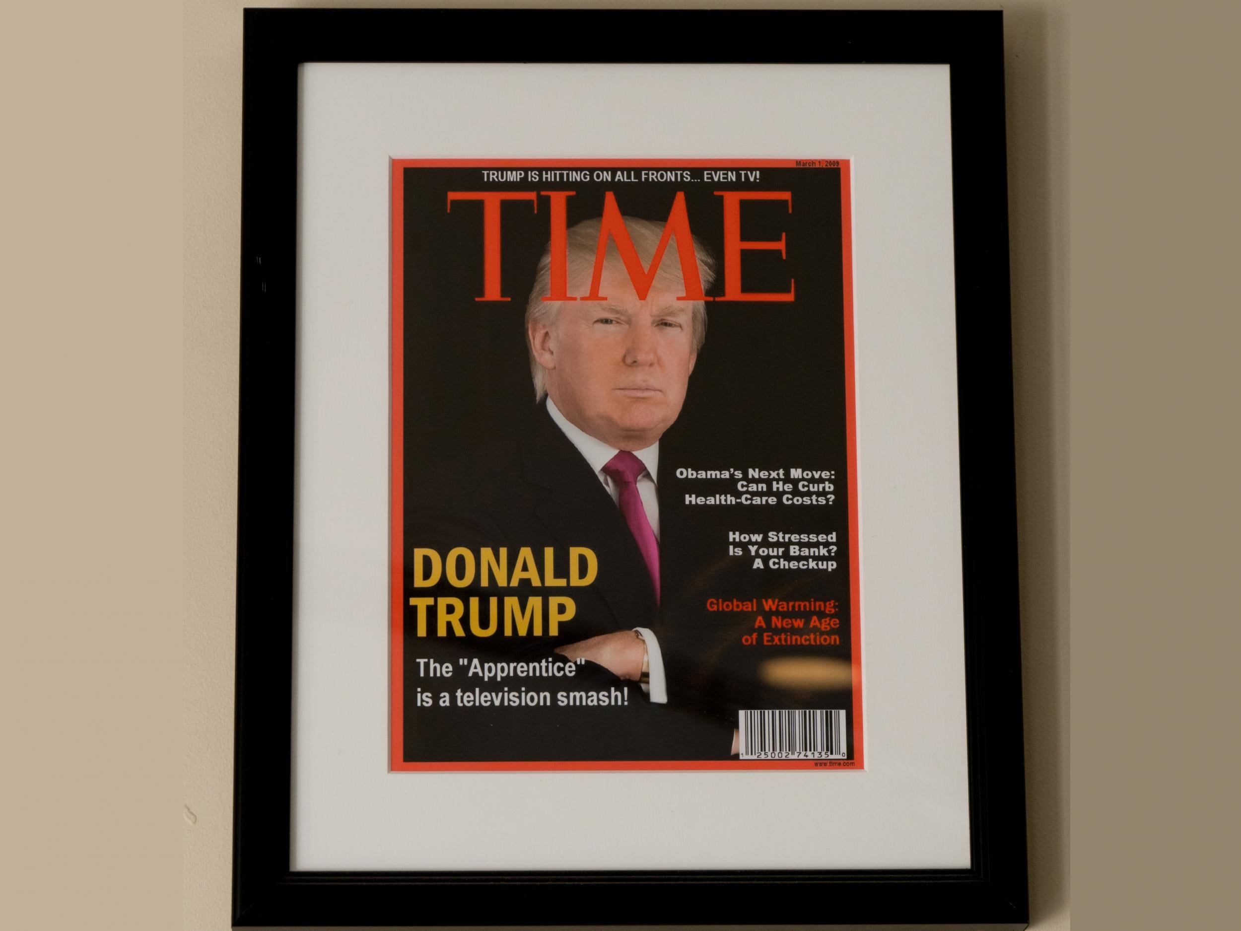 Framed portrait of President Donald Trump on the cover of a Time magazine and other magazine covers framed and hanging from a wall at the Trump National Doral Miami Golf Shop