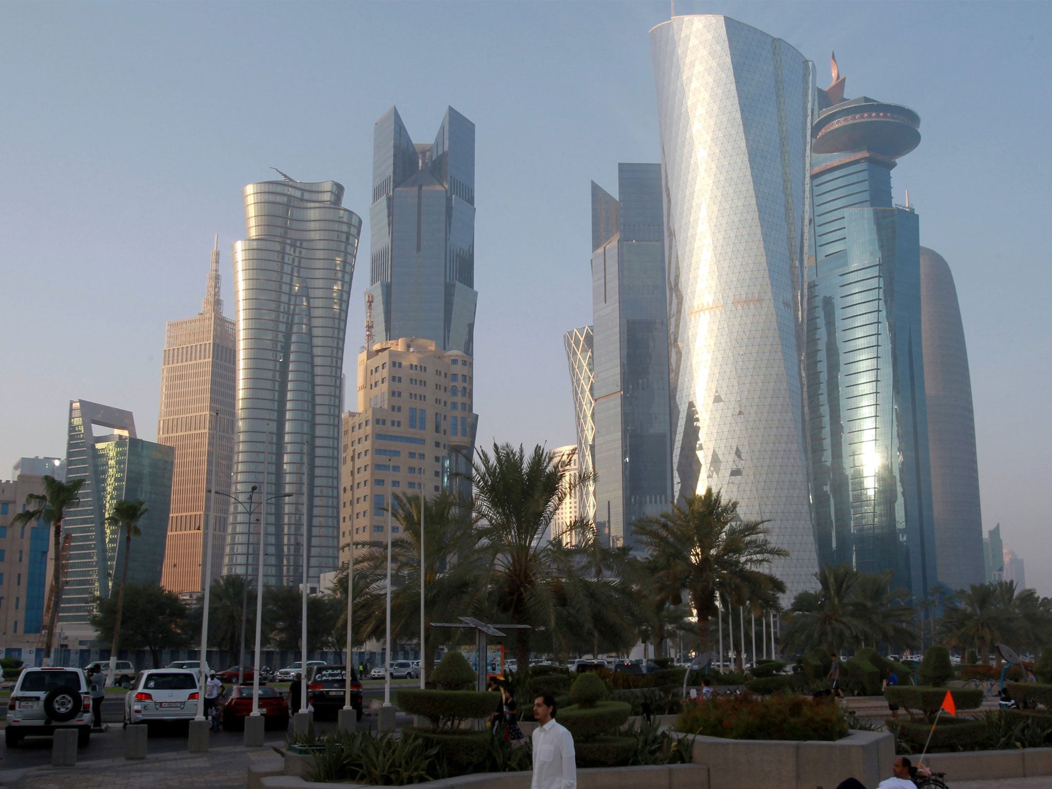 A man walks on the corniche in Doha, Qatar