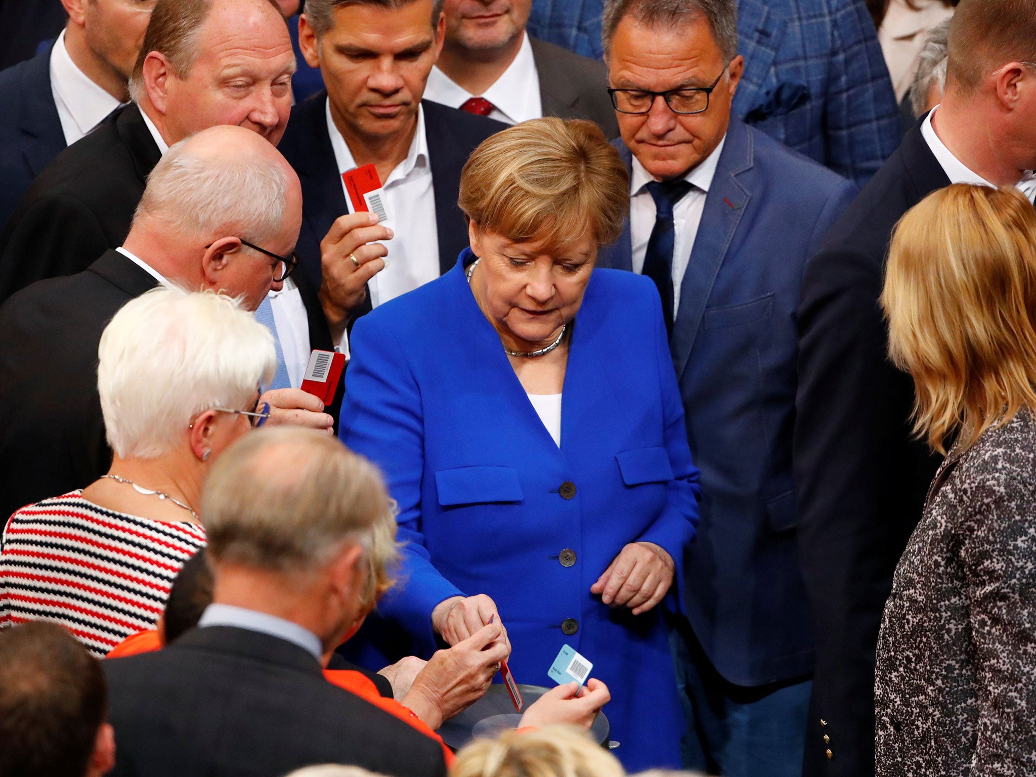 The German Chancellor was seen voting with a red card, indicating a no vote