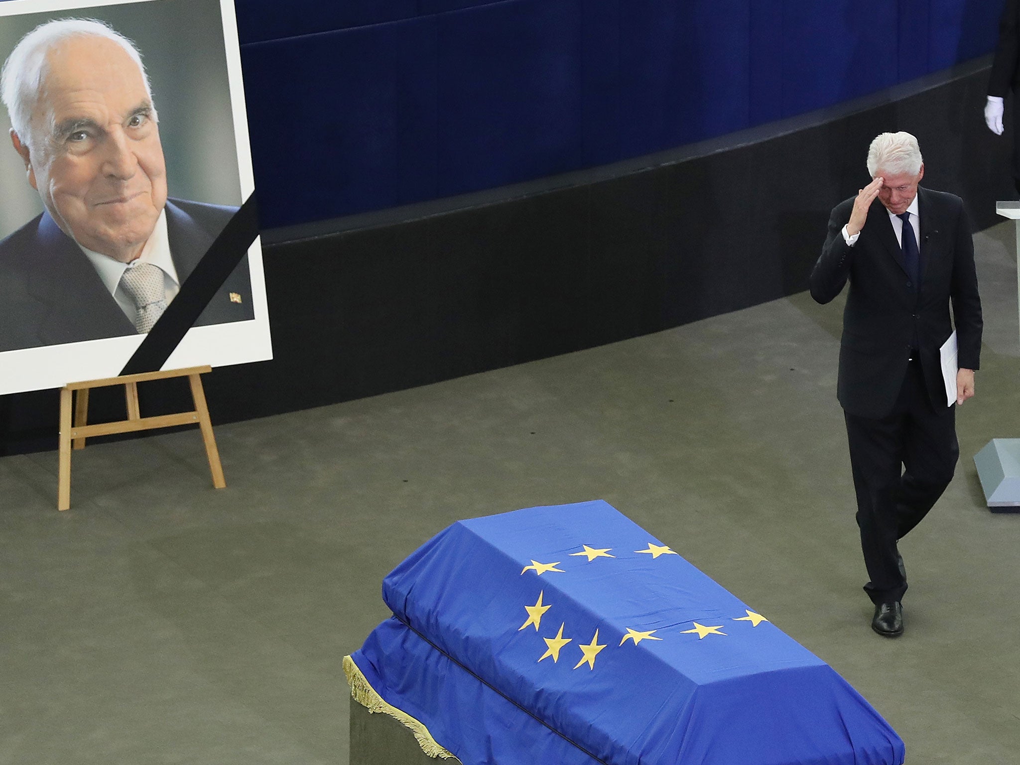 Bill Clinton salutes towards the coffin of late former German Chancellor Helmut Kohl after speaking at a memorial at the European Parliament in Strasbourg, on 1 July 2017