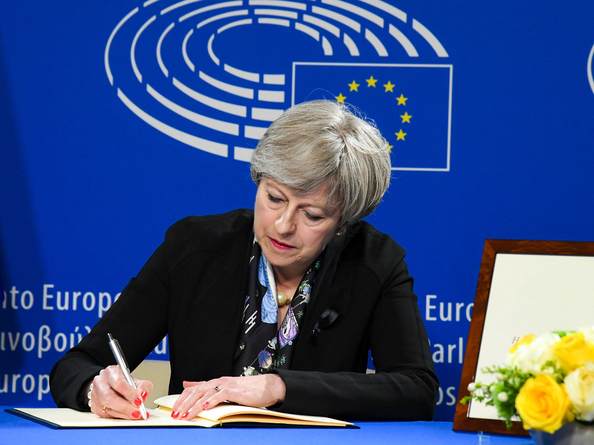 Theresa May signing the book of condolences at the European Parliament as world leaders gather for a memorial to late German chancellor Helmut Kohl in Strasbourg, France, on 1 July