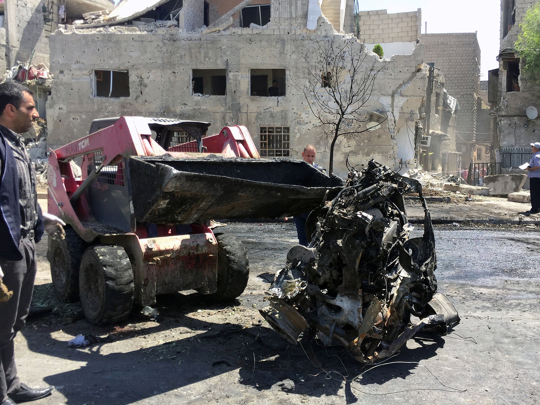 People inspect the damage at one of the blast sites in Damascus