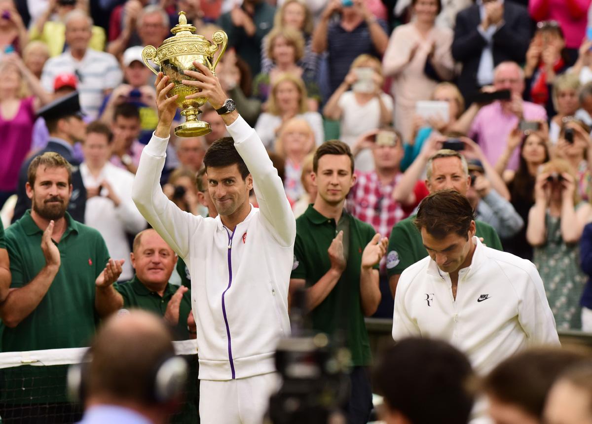 Novak Djokovic with the trophy with Roger Federer on Centre Court, in 2015.