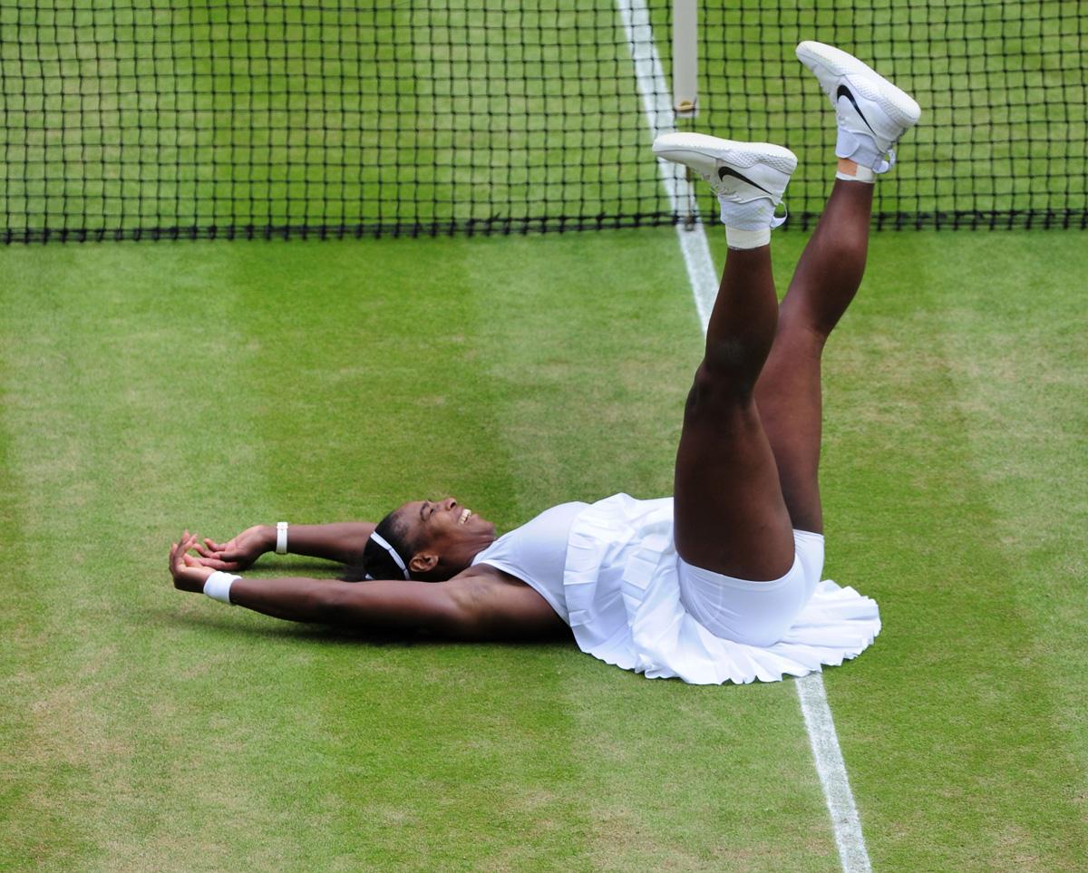 Serena Williams falls to the ground after winning match point on Centre Court in 2016.