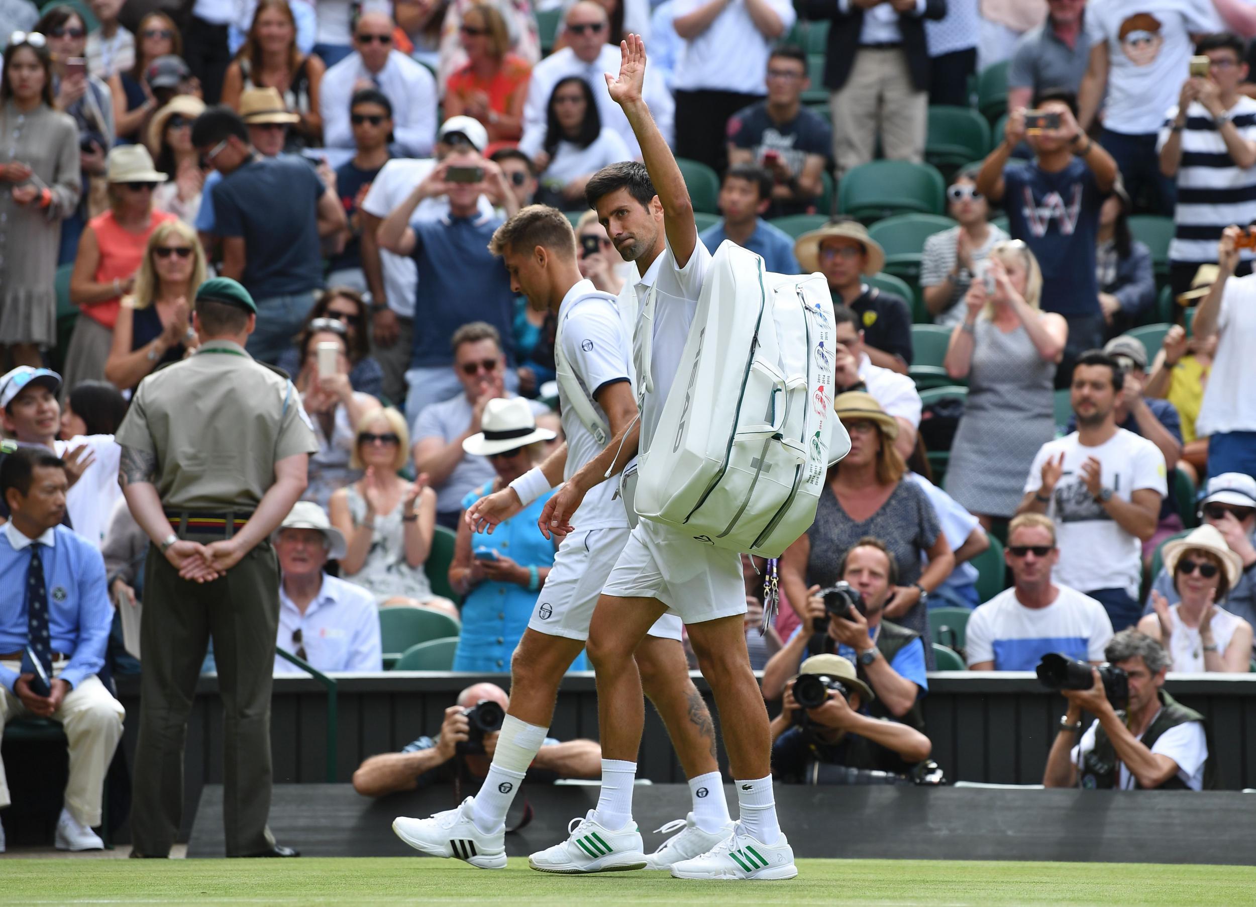 Djokovic walks off with Klizan after the Slovakian retired injured