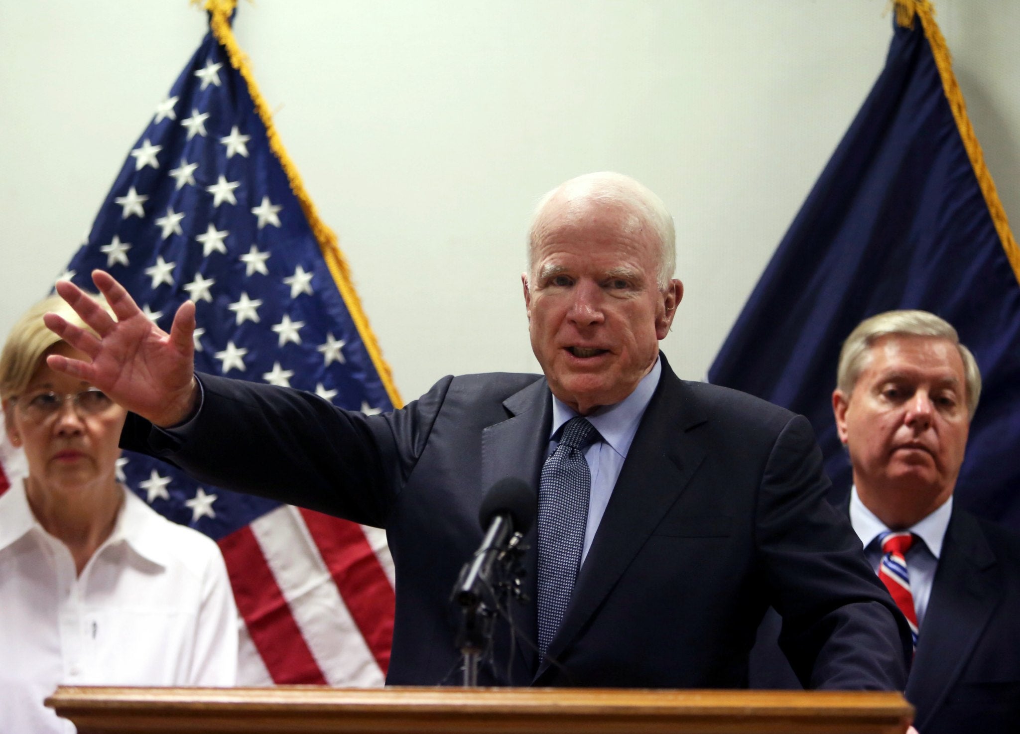 Senator John McCain, centre, speaks during a press conference in Kabul, with Senators Elizabeth Warren, left, and Lindsey Graham in the background