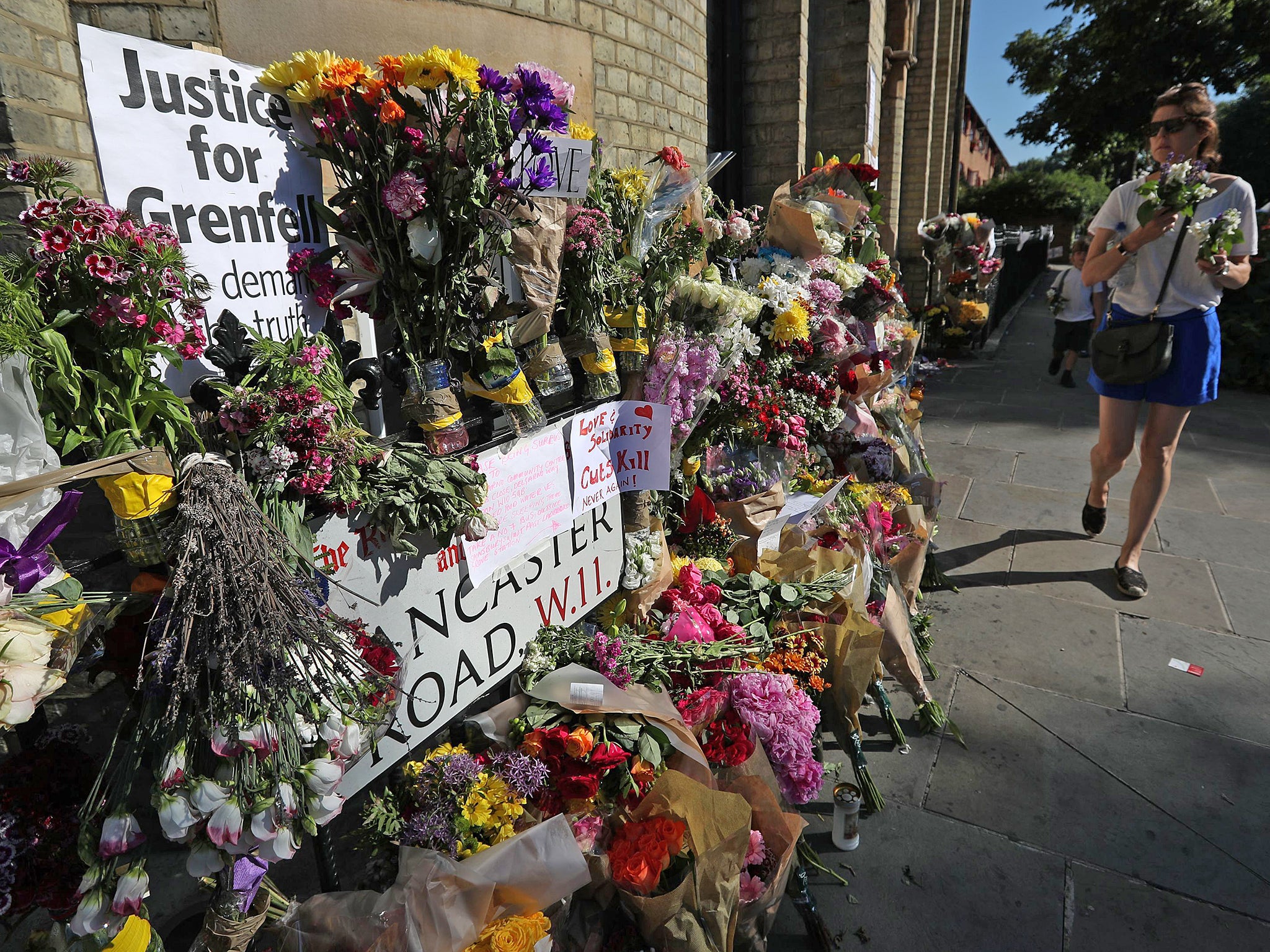 Flowers are left to commemorate the victims of the Grenfell Tower disaster