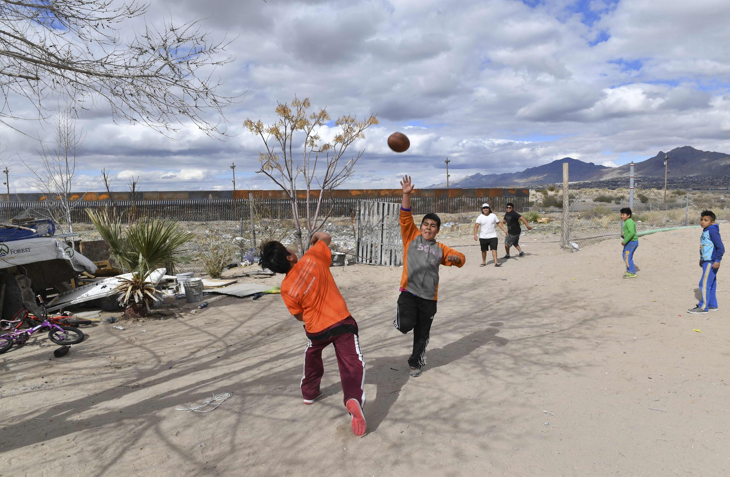 Mexican children who live near to the metal fence between their country and the United States play football in Puerto Anapra, Chihuahua state